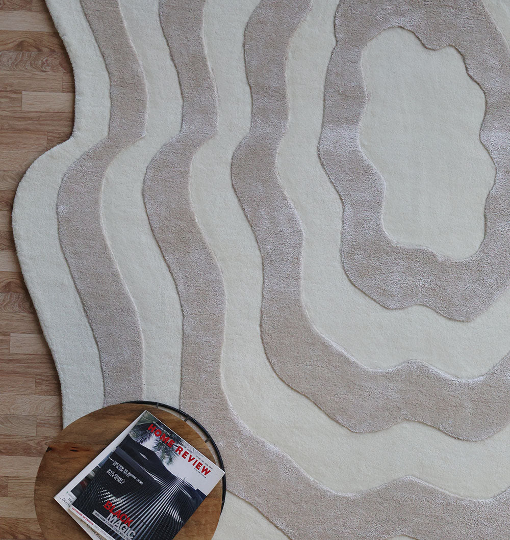 Close-up detailing the luxurious texture underfoot of the beige and cream rug, emphasizing the high-viscose blend for superior softness.