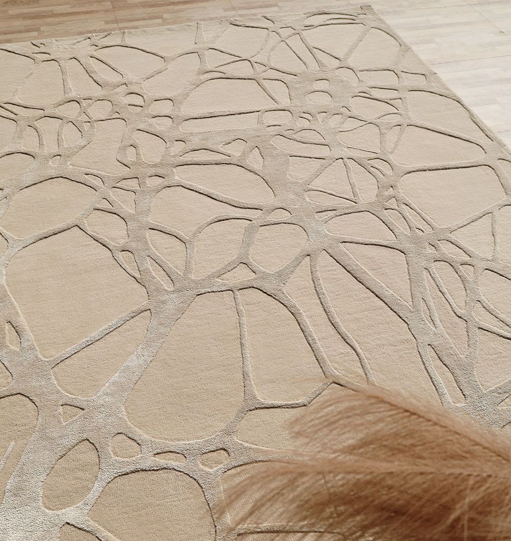 The RAMSHA HOME Natural White Color Handmade Area Rug (HTWV-145, 200x300 cm) features a web-like raised wool pattern on a light wood floor, complemented by modern tan decorative strands in the corner.