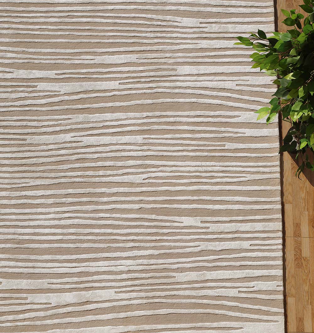 The RAMSHA HOME Natural Color Handmade Area Rug - HTWV-147 (300x400 cm) in beige and white with a wavy striped pattern lies on a wooden floor, accented by green leafy branches in the upper right corner.