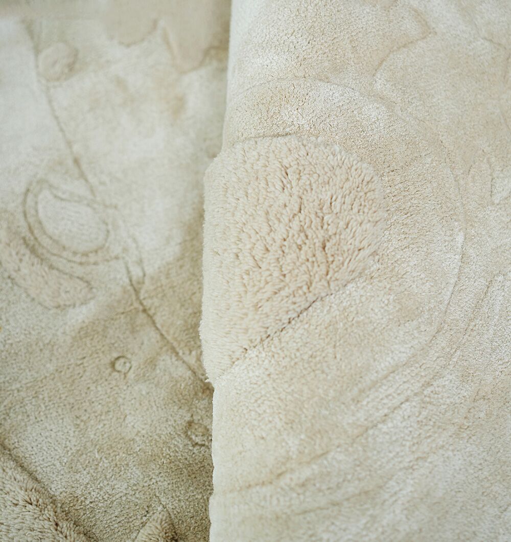 Close-up of the plush texture and folds of the Natural Color Handmade Area Rug - HTWV-150 (200 cm) by RAMSHA HOME, showcasing its soft beige fabric with a subtle embossed pattern.