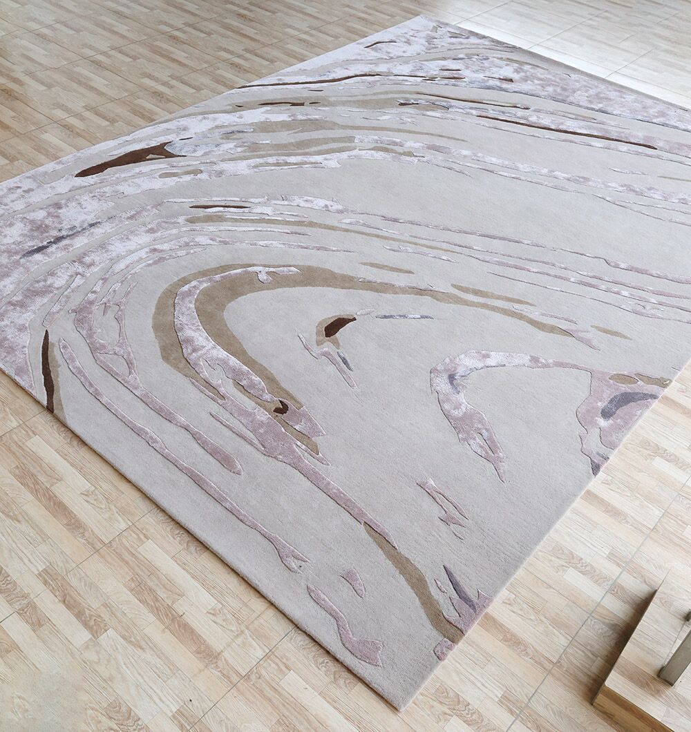 The RAMSHA HOME Multi Color Handmade Rug - HTWV 158 (300x400 cm) adds subtle elegance to a light wood parquet floor with its modern abstract design in beige, light pink, and brown tones.