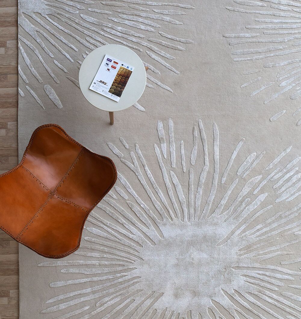 A tan leather chair sits next to a small round table holding a color swatch booklet, all placed on the RAMSHA HOME Rectangle Home Decor Light Beige Color Rug - HTWV 160 (300x400 cm).