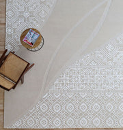 The Boho Geometric Handmade Decorative Area Rug - HTWV 167 (300x400 cm) by RAMSHA HOME lies on the floor, topped with a wooden chair and round side table holding a magazine in its stylish top left corner.