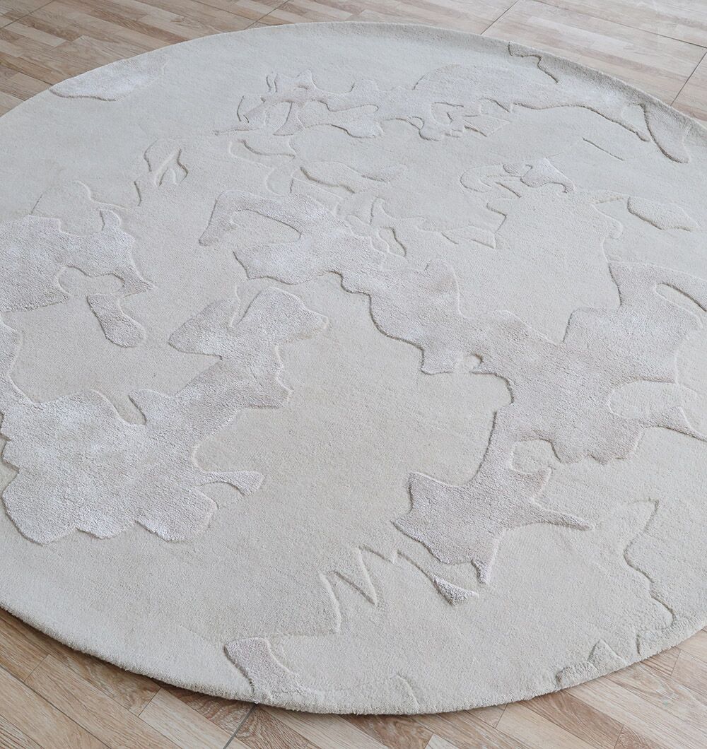 The RAMSHA HOME Round Home Decor Handmade Rug - HTWV 170 (200 cm) in off-white, featuring subtle raised abstract patterns, brings warmth and visual interest to light natural wood floors.