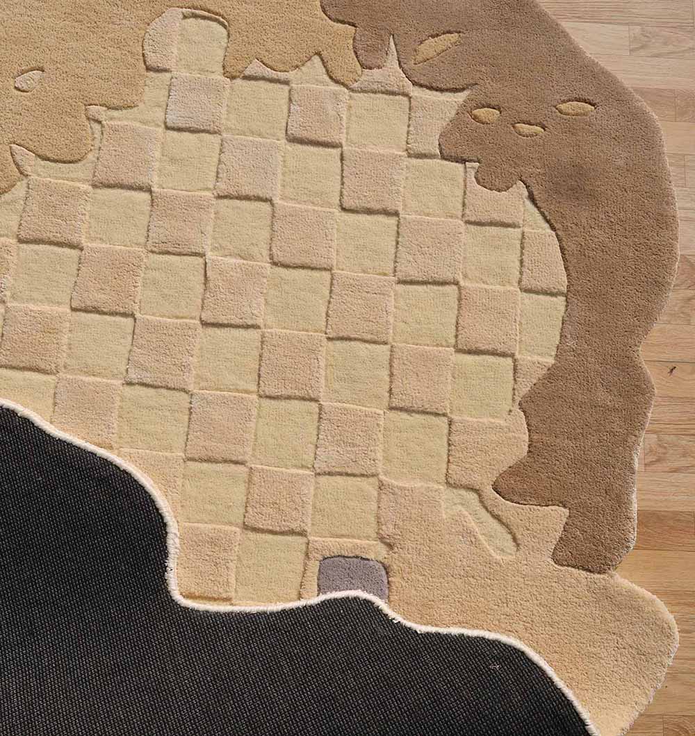 The Abstract Shaped Handmade Area Rug- HTWV 174 (200x300 cm) by RAMSHA HOME features a checkered beige and tan center, an irregular brown border, a black corner, and a small gray patch, adding modern flair to any wooden floor.