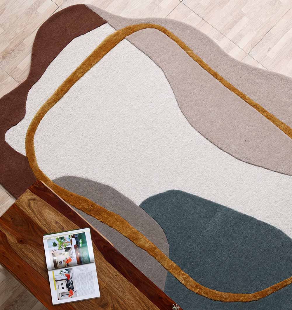 The RAMSHA HOME Handmade Multi Color Shaped Area Rug 200x300 CM HTWV 186, with wavy cream, beige, brown, mustard yellow, and dark blue shapes, adds a modern neutral touch to light wood floors and complements wooden tables.