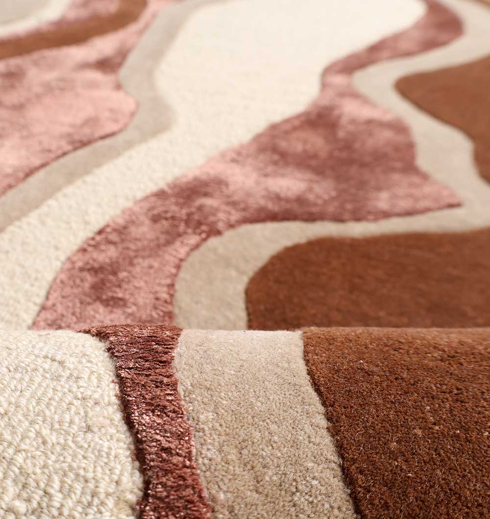 Close-up of the RAMSHA HOME Decorative Handmade Multi Color Shaped Area Rug – HTWV 187, a hand-tufted wool rug showcasing wavy abstract patterns in beige, brown, and rose pink with plush, varied pile heights for a 3D effect.