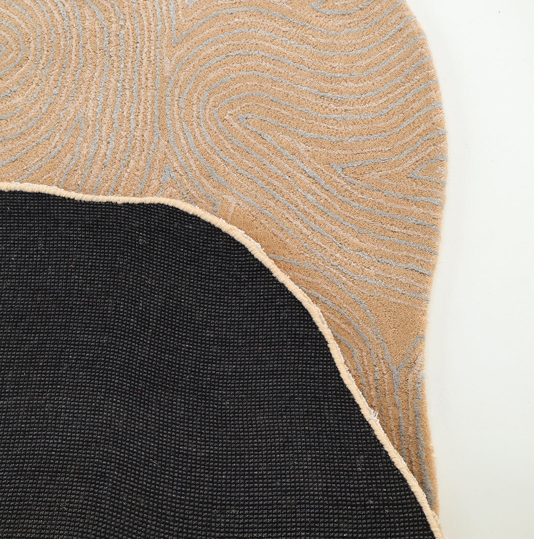 A close-up of the RAMSHA HOME Handmade Beige Abstract Shaped Rug 200 cm (HTWV-188), showcasing its hand-tufted design with organic, wavy beige and gray patterns on one side, contrasted by a solid black textured section on the other, separated by a curving light border—an elegant example of an abstract pattern rug.