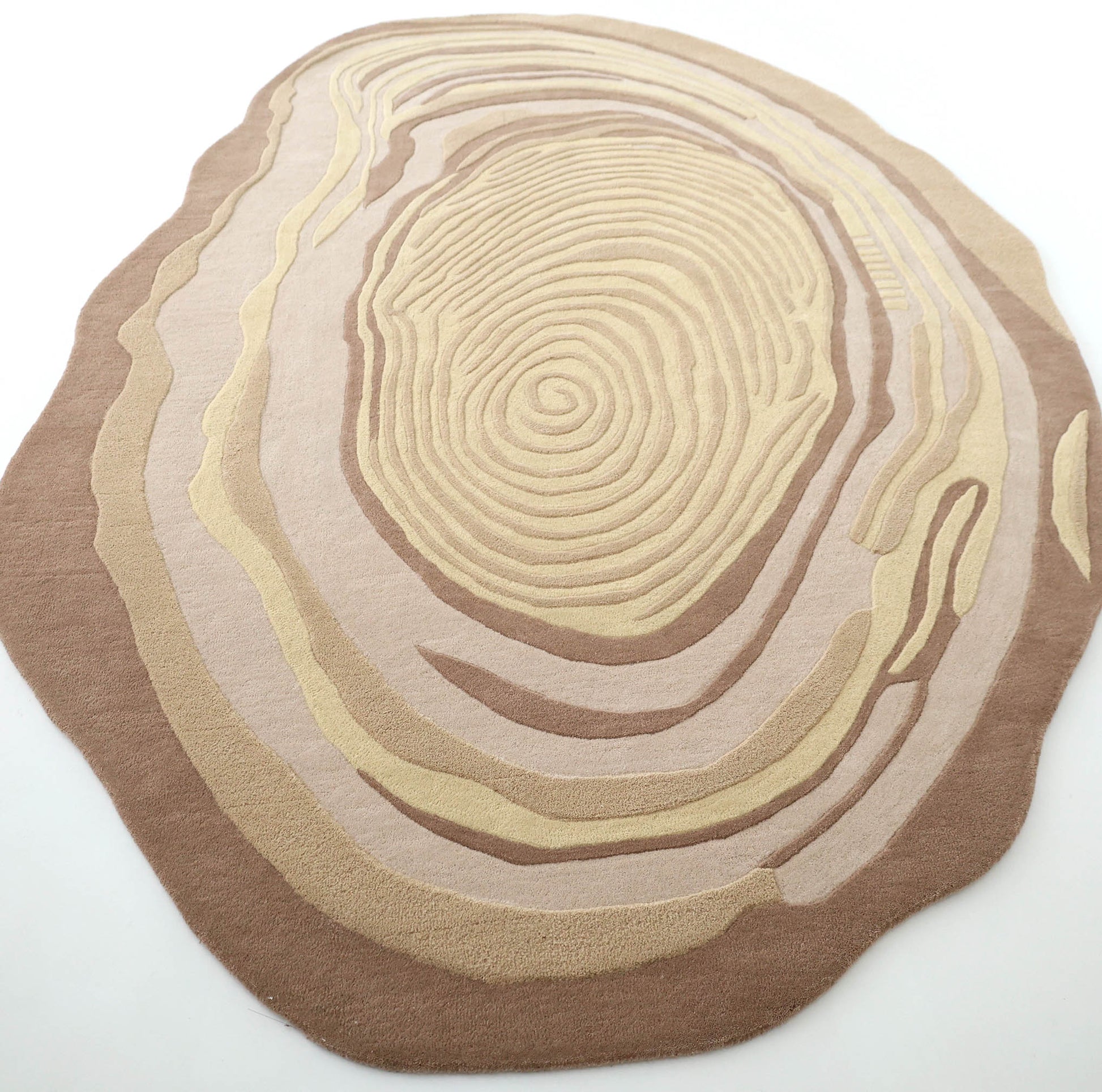 The RAMSHA HOME Terra Eclipse Oval Handmade Rug (HTWV-155) features a beige and brown design with concentric rings, resembling tree trunk cross-sections or topographic lines.
