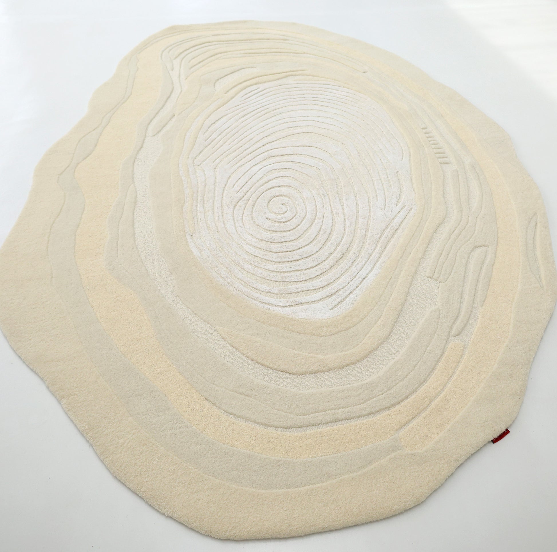 The RAMSHA HOME Ivory Topographic Shaped Rug 200x300 cm (HTWV-192) features an off-white and beige design inspired by topographic map rings, shown on a light floor.