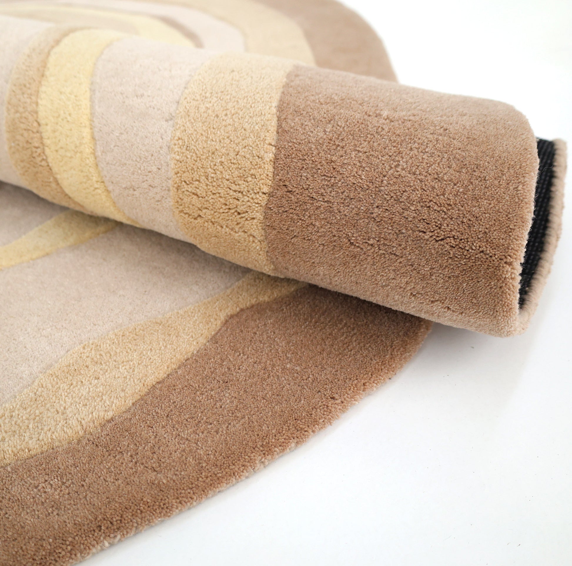 A close-up of the RAMSHA HOME Terra Eclipse Oval Handmade Rug HTWV-155, featuring plush, wavy patterns in beige, tan, and brown—an ideal multicolored accent rug for modern interior decor.