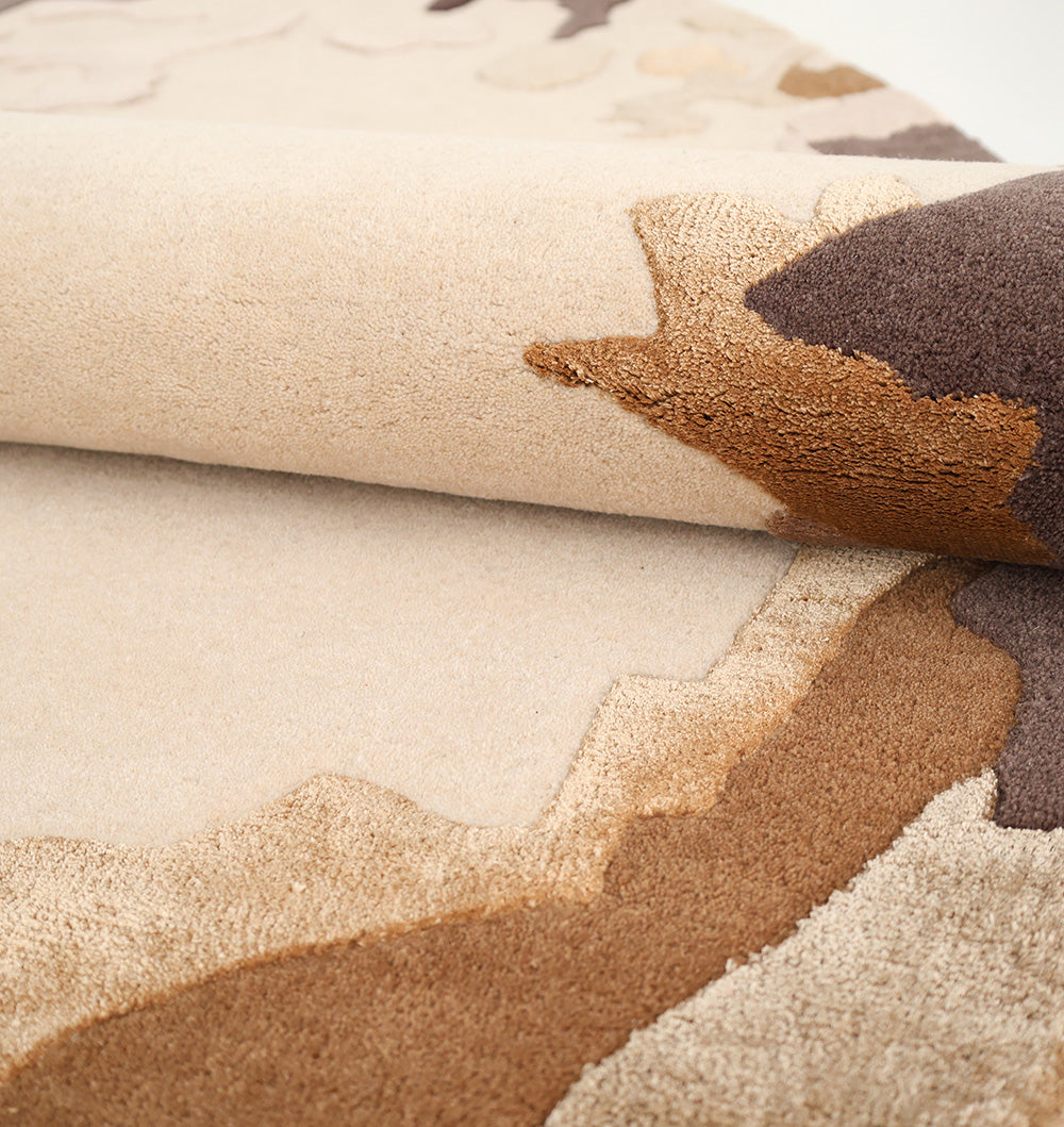 A close-up of the RAMSHA HOME Terra Eclipse Oval Handmade Rug Accent Rug HTWV-195 shows its beige and brown abstract border, textured pattern, and varied pile heights—ideal for adding a modern touch to your space.