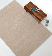 The RAMSHA HOME Rectangle Modern Handmade Rug 200x300 CM HTWV-197, featuring an abstract beige design, is placed beside a wooden coffee table with magazines and a plant vase, set on a light floor.