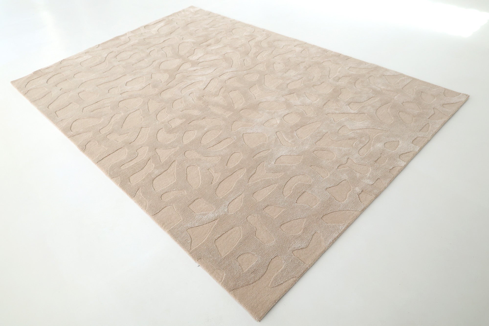 The RAMSHA HOME Rectangle Modern Handmade Rug 200x300 CM HTWV-197 in beige features abstract, raised textures and is shown on a smooth white floor.
