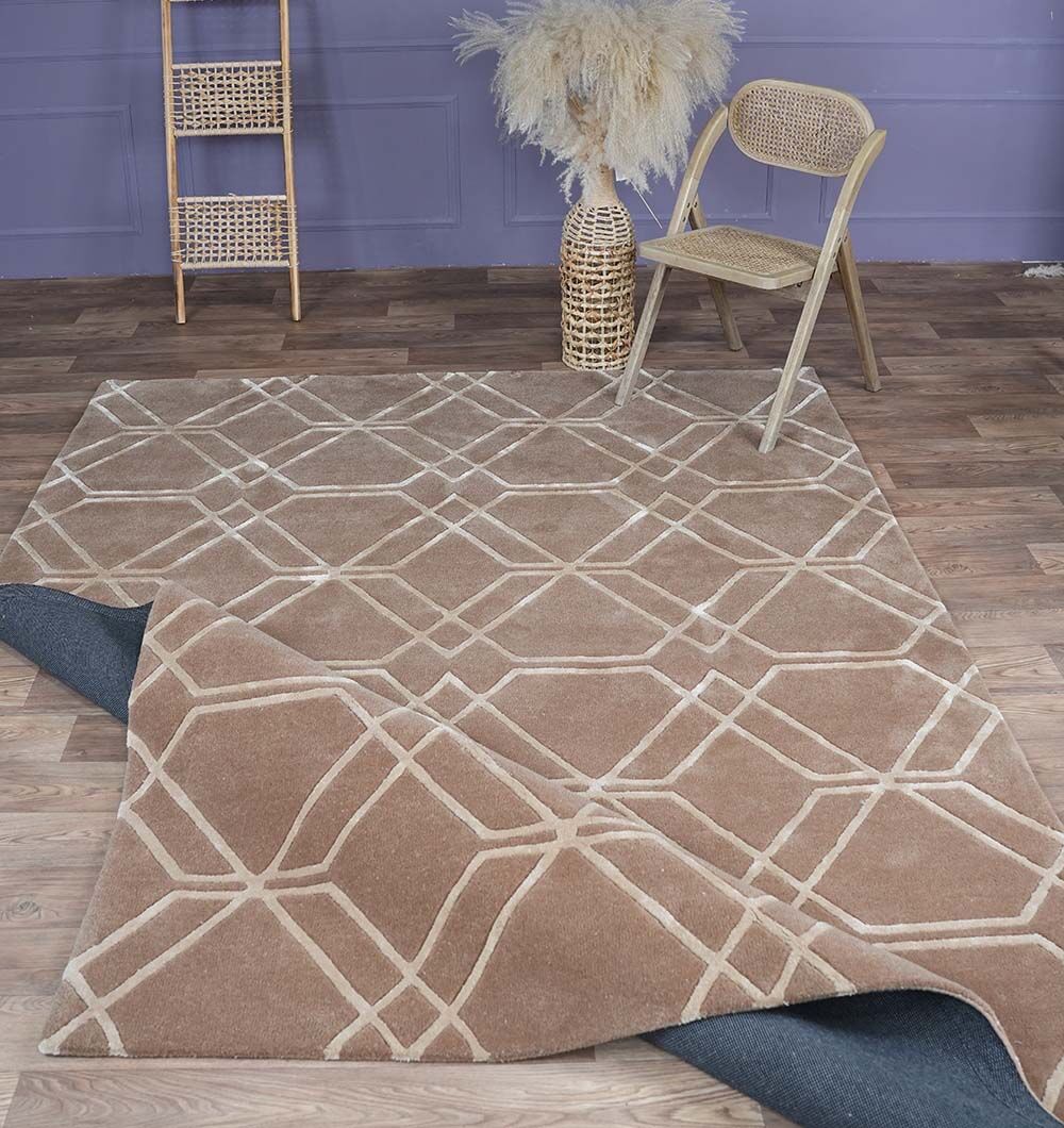 A modern living space features the RAMSHA HOME Stunning Multi Color Hand-Tufted Rug - HTWV 21 (200x300cm), partially lifted to show a black rug pad. The room includes a rattan chair, ladder shelf, pampas grass vase, and purple wall paneling.