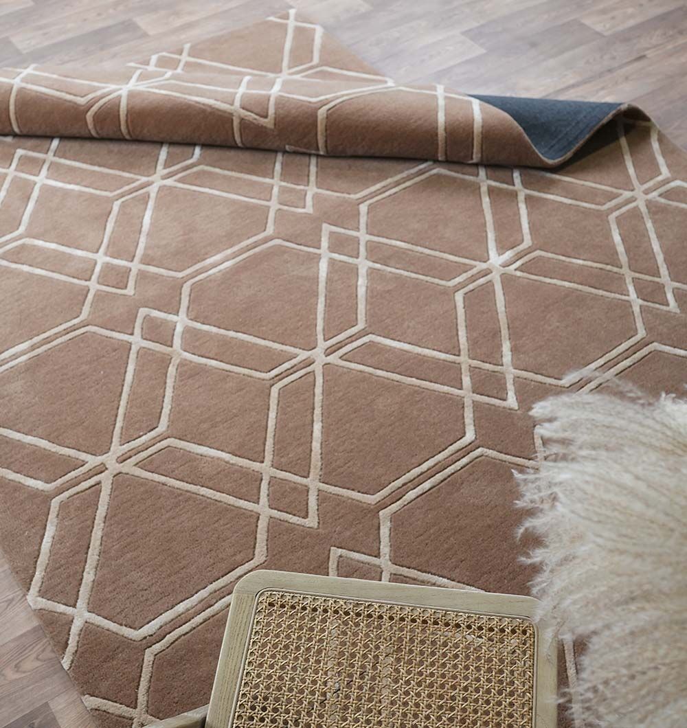 The Stunning Multi Color Hand-Tufted Rug - HTWV 21 (200x300cm) by RAMSHA HOME is partially folded on a wooden floor, with a woven seat and fluffy decor visible in the foreground.