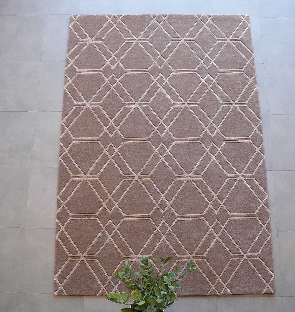 The RAMSHA HOME Stunning Multi Color Hand-Tufted Rug - HTWV 21 (200x300cm) with geometric patterns lies on a light gray tiled floor, while a green leafy plant appears partially at the bottom of the image.