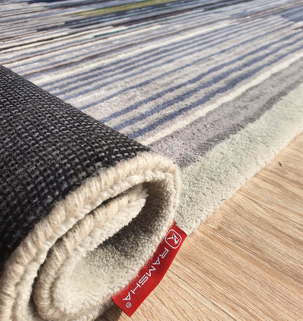 Image of the multi-color rug rolled up for transport or storage, showing the density and quality of the materials.