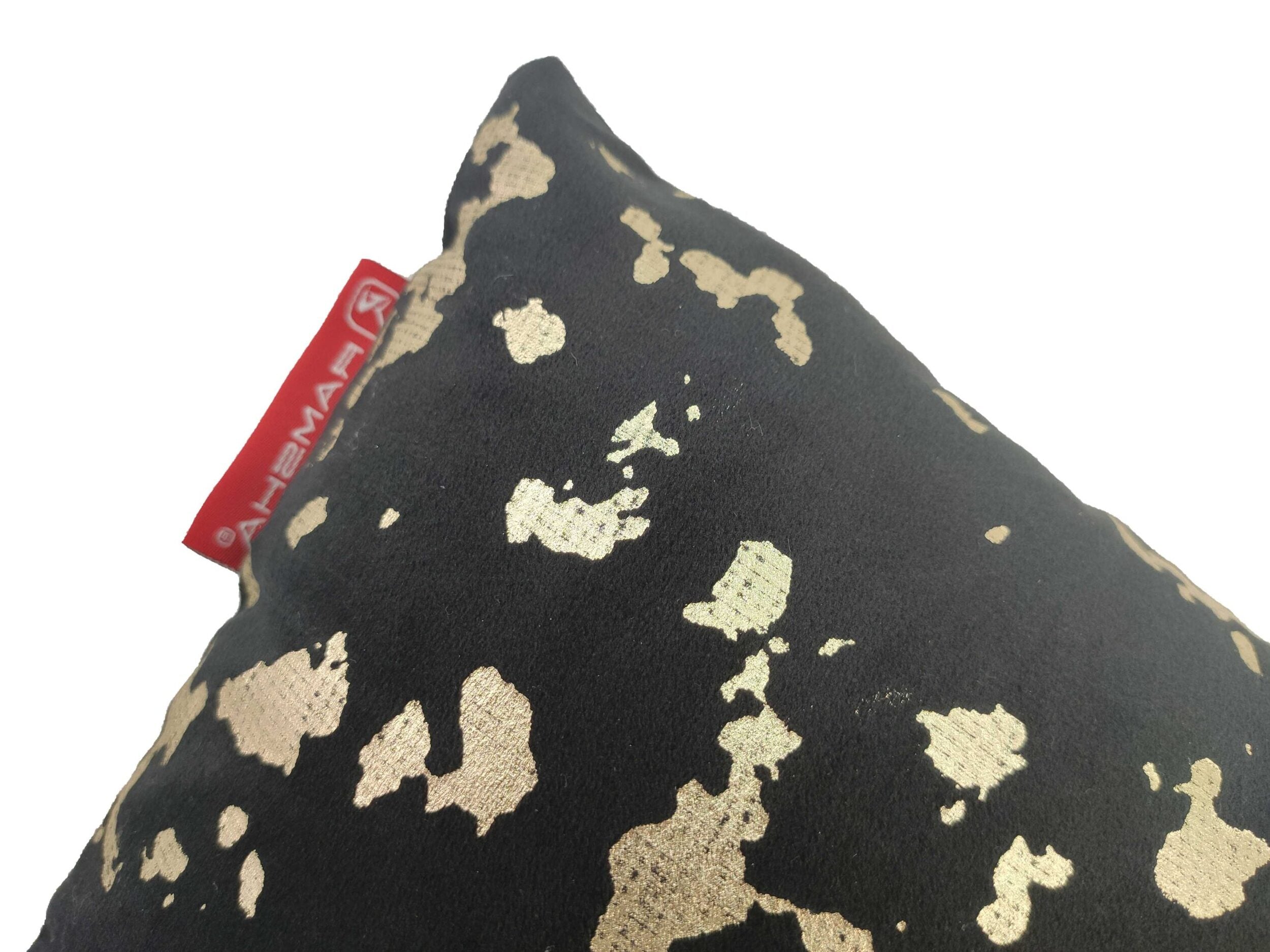 A close-up of the RAMSHA HOME Black Cushion With Filler CS-094, featuring irregular gold patterns and a red fabric tag against a white background—an elegant touch for your home decor.
