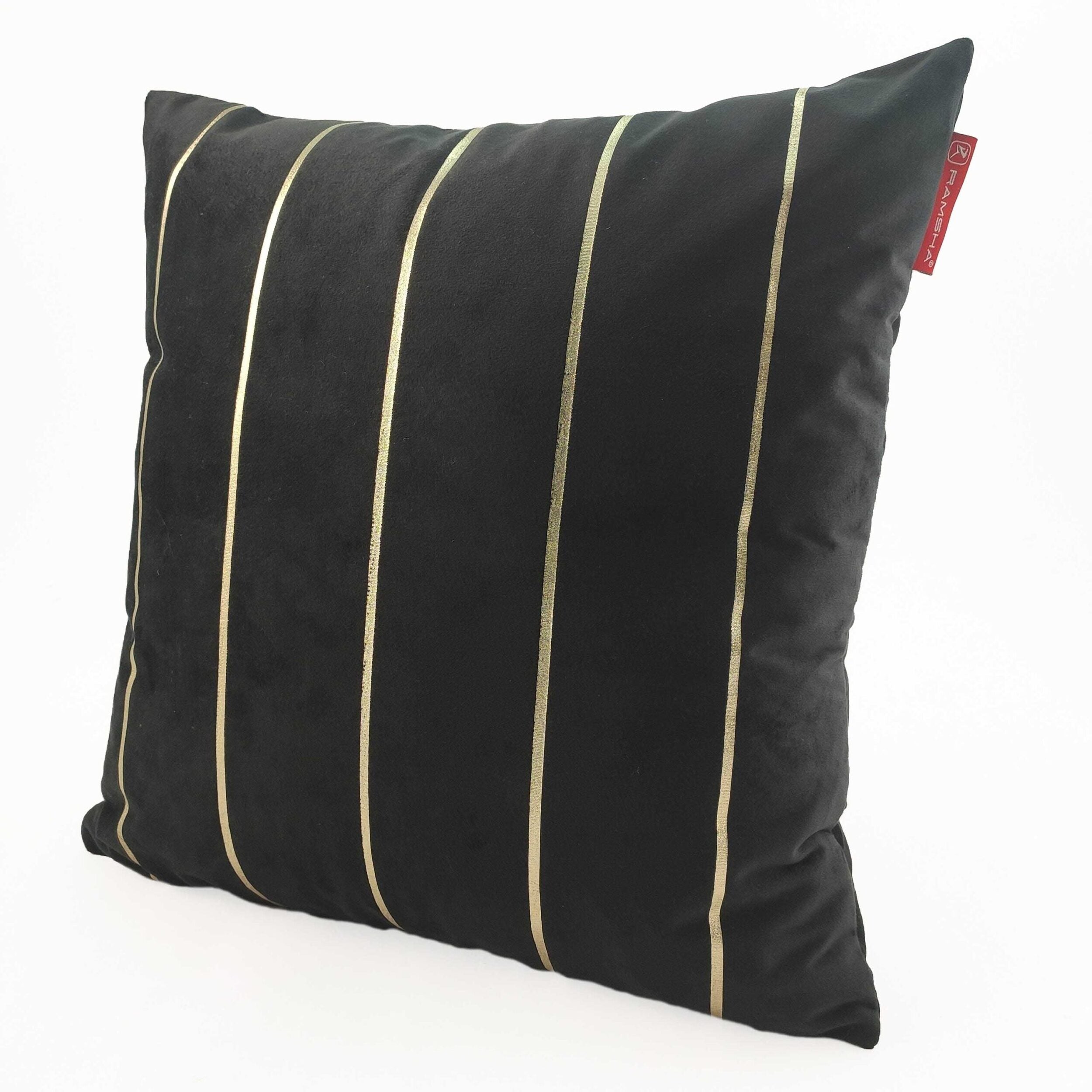 The RAMSHA HOME 100% Polyester Cushion Cover CS-099 is a black throw pillow with thin vertical gold stripes and a red tag on the top right edge, featuring a durable cover and shown against a white background.