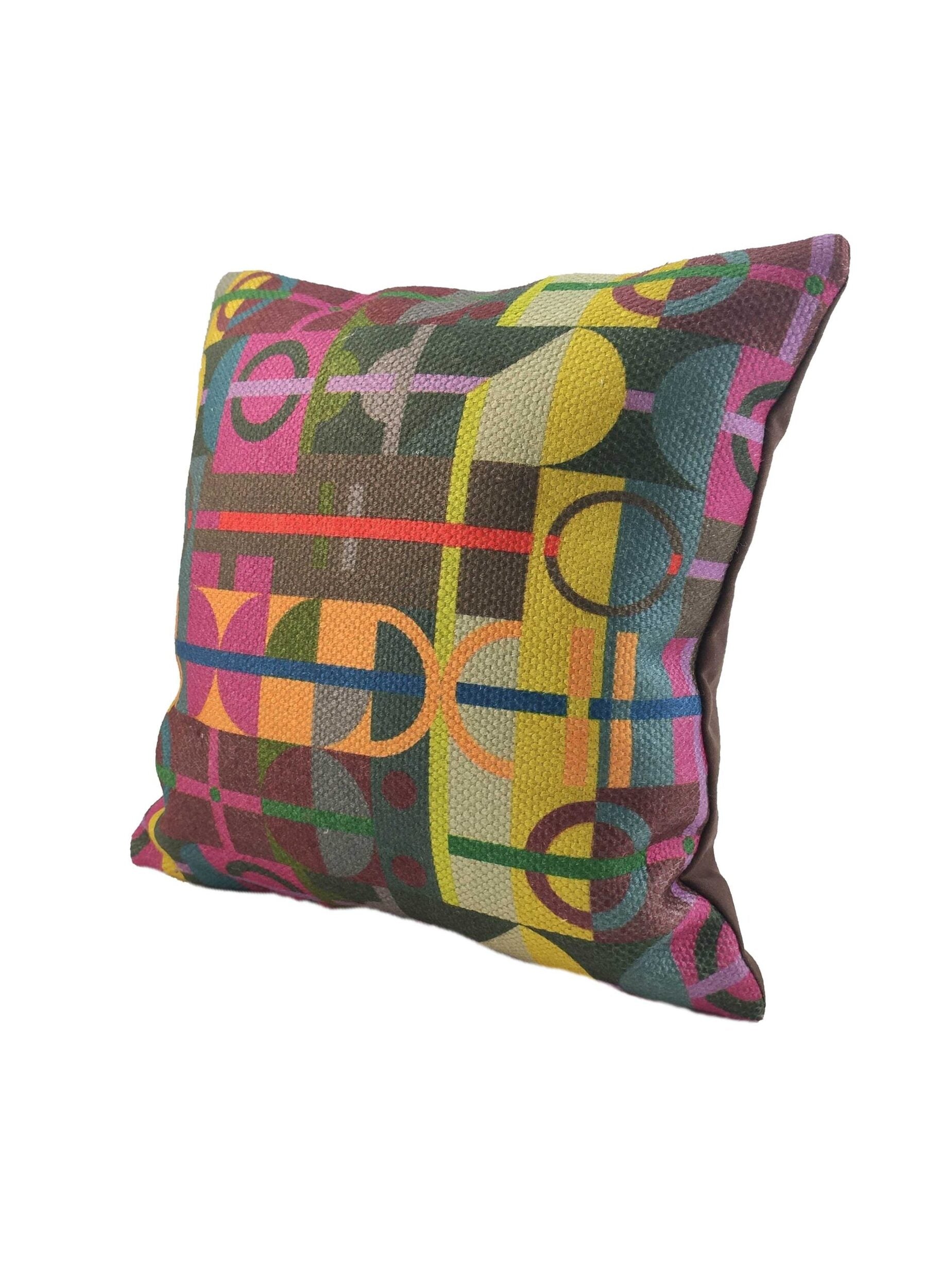 The RAMSHA HOME Multi Decor Cushion Cover CS-070 is a square cover made from high-quality fabric, featuring a vibrant geometric pattern with overlapping circles, lines, and shapes in yellow, pink, green, blue, and brown.