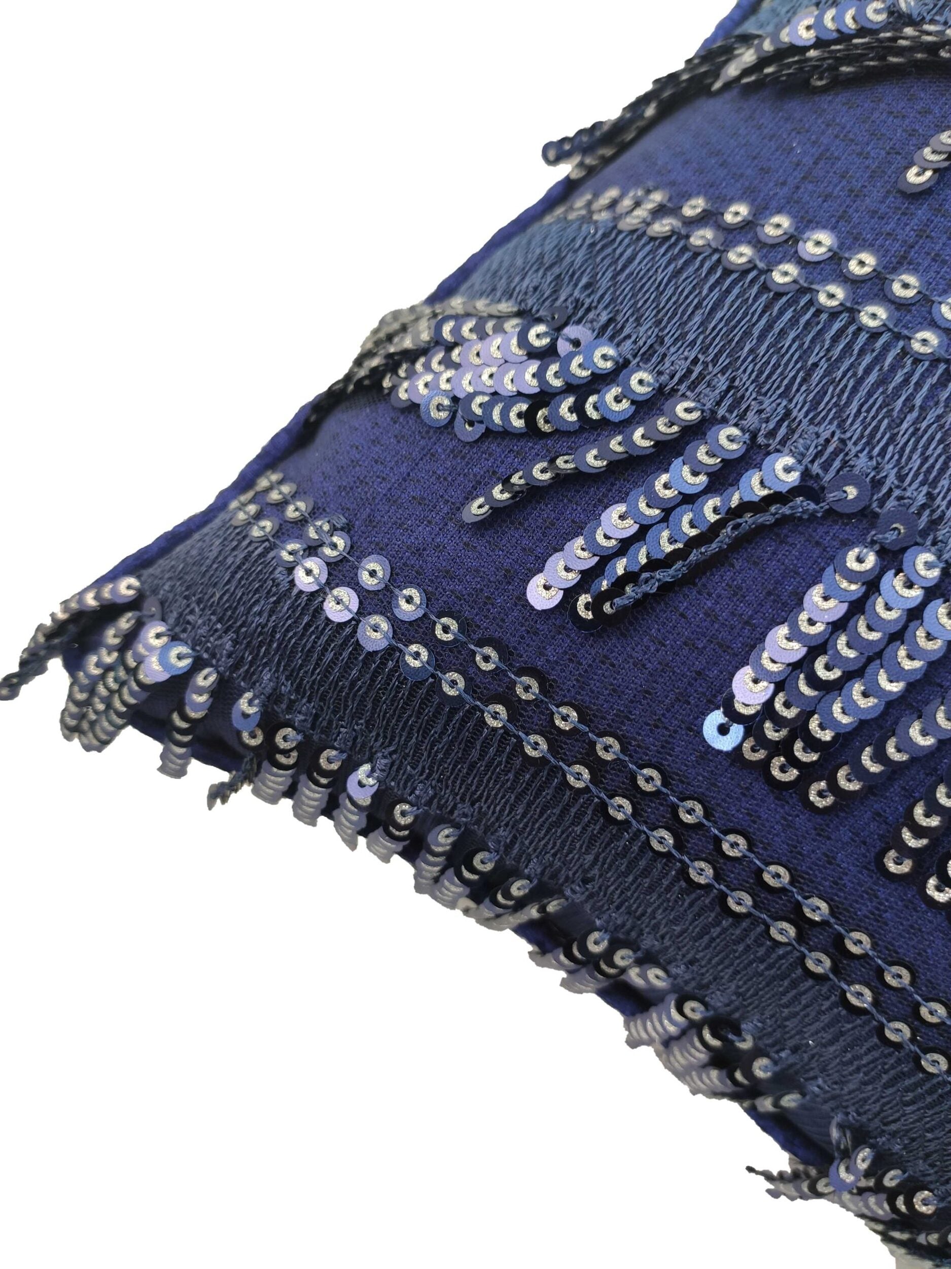 Close-up of the RAMSHA HOME Polyester Sequence Cushion With Filler, showcasing dark blue textured fabric and rows of shiny sequins in linear and zigzag patterns for a stylish look and comfortable support.