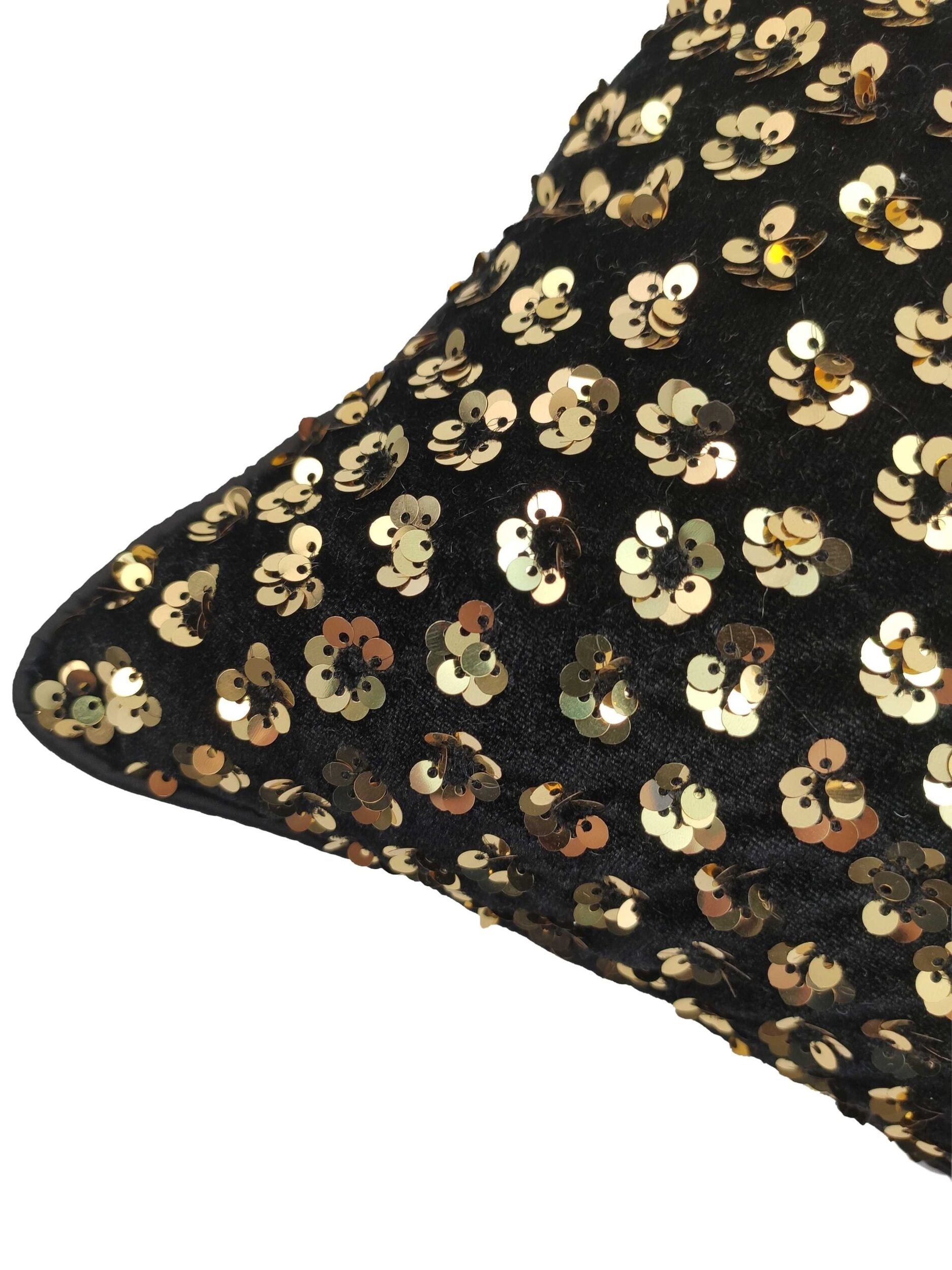 A close-up of the RAMSHA HOME Polyester Cushion With Filler showcases black polyester fabric adorned with gold sequins in a floral pattern, providing both elegant decor and comfortable seating.
