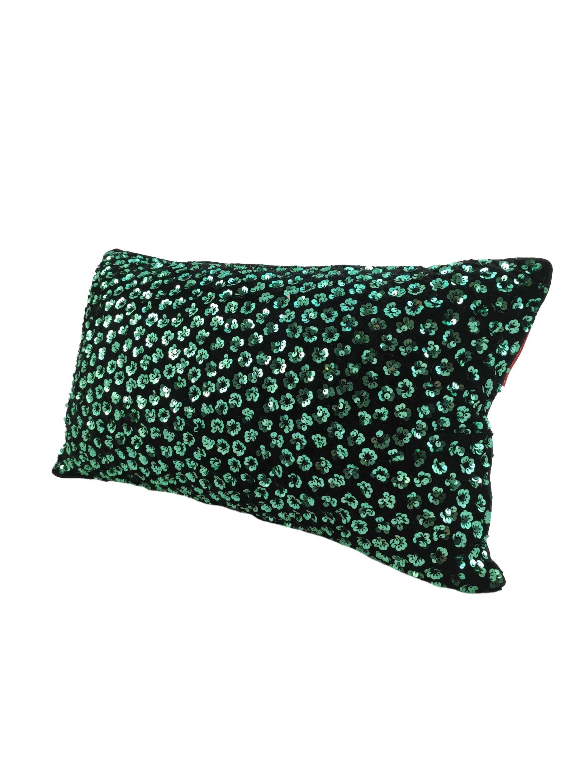 The RAMSHA HOME Polyester Cushion With Filler features a black background with shiny green sequin dots, offering a sparkly, textured look. This rectangular cushion provides comfortable seating and is shown against a white background.