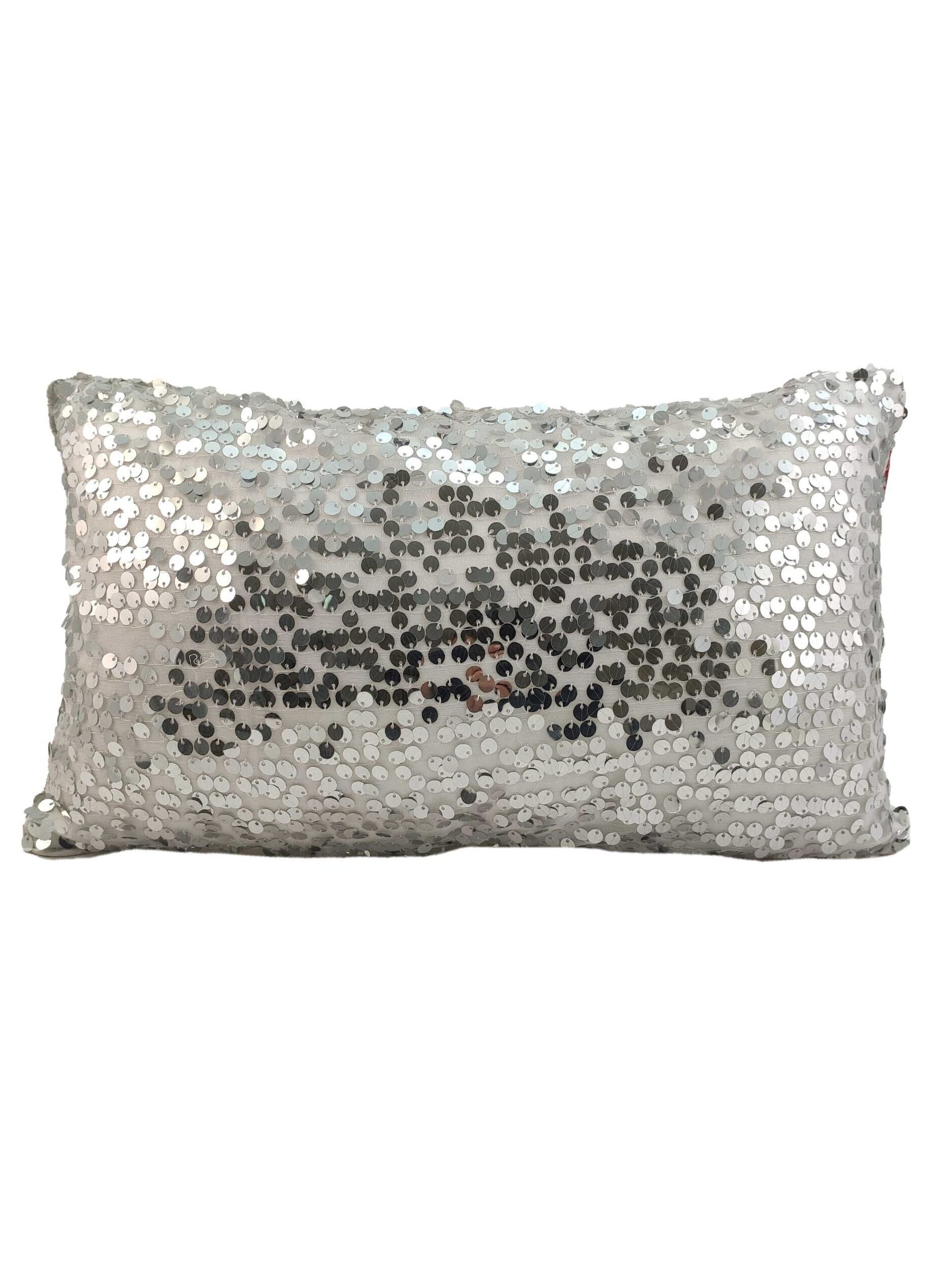 The RAMSHA HOME Sequence Cushion With Filler features a rectangular shape covered in shiny silver sequins, which can be brushed to reveal a darker pattern, and offers superior comfort with its plush inner cushion.