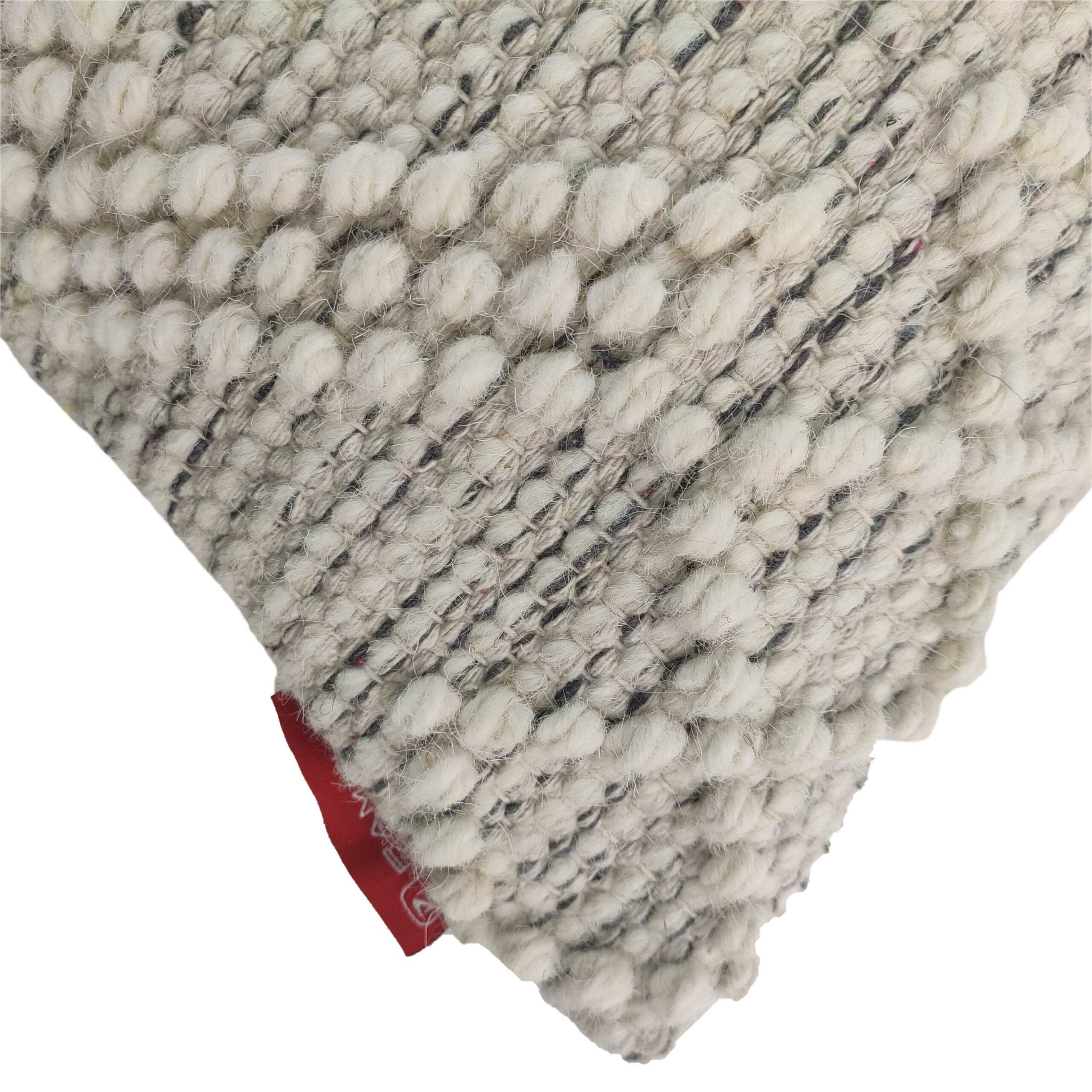 Close-up of the RAMSHA HOME Wool & Cotton Cushion With Filler CS-046, featuring thick yarn and raised bobbles in textured off-white fabric. A small red fabric tag appears near the corner. Shown on a plain white background.