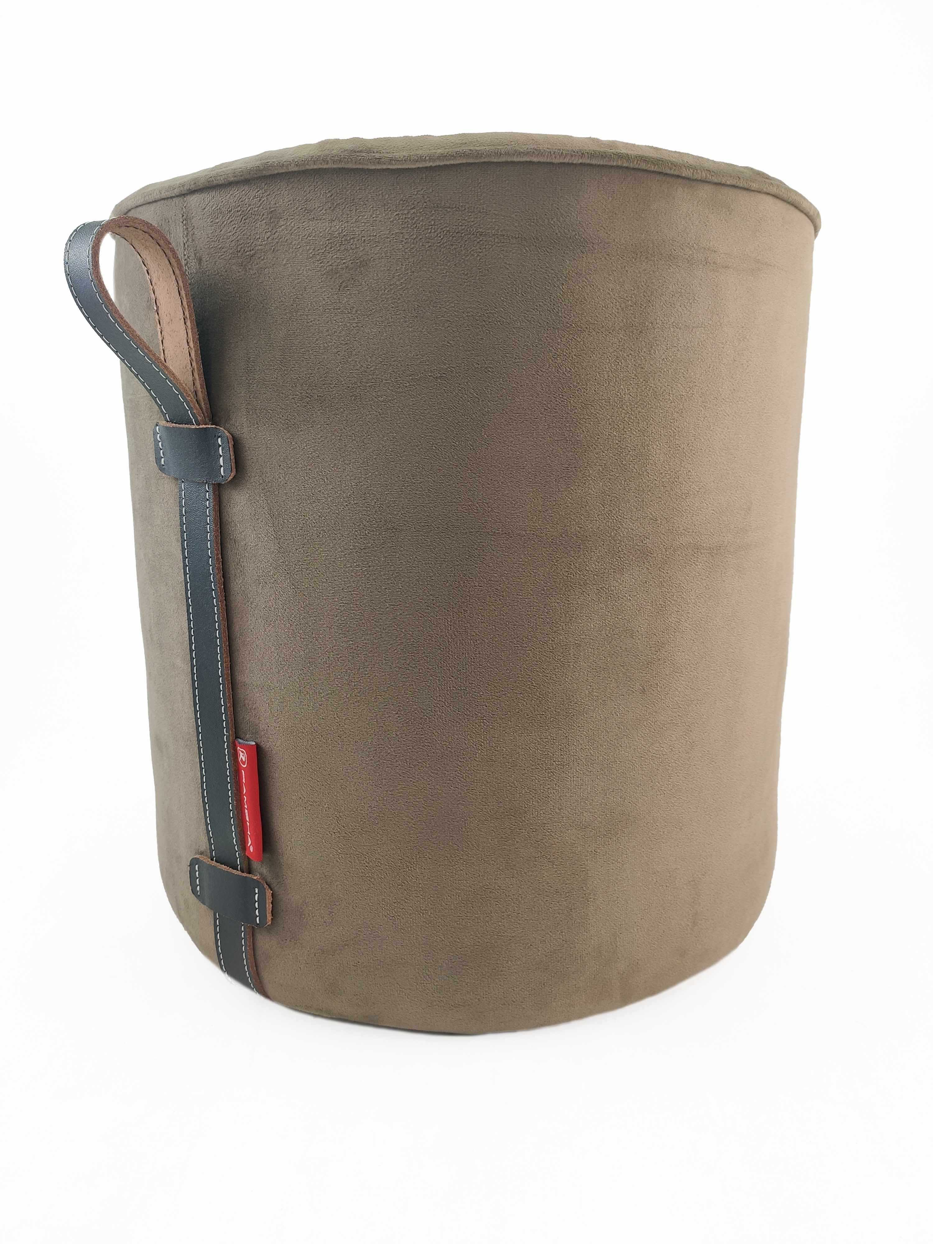 The RAMSHA HOME Leather Pedestal Pouf features brown leather with a smooth finish, a black leather handle with white stitching, and a small red side tag, all set against a plain white background.