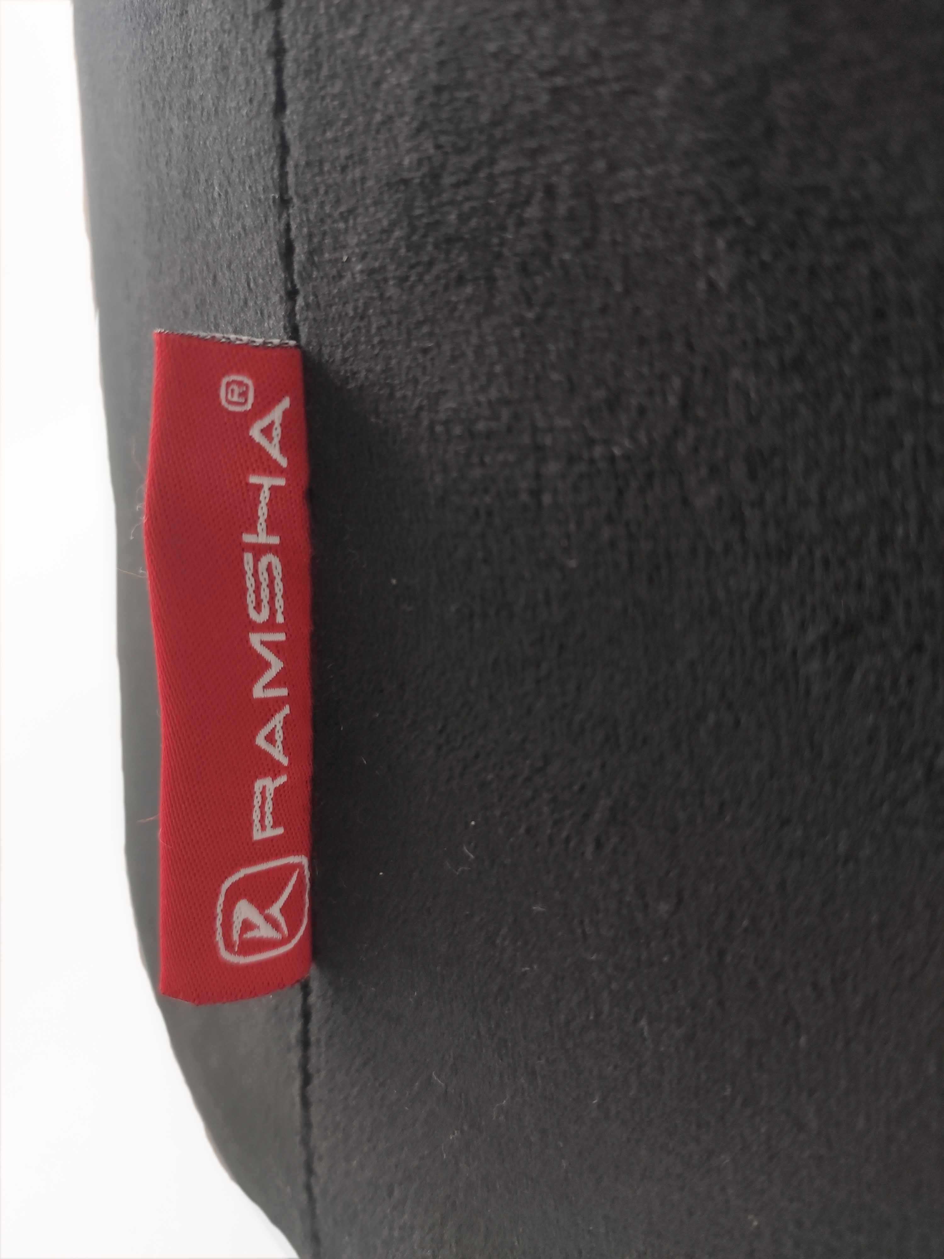 Close-up of a black fabric surface with a red tag reading RAMSHA HOME in white, plus logo—showing the perfect detailing on the Leather Pedestal Pouf With Leather Handle.