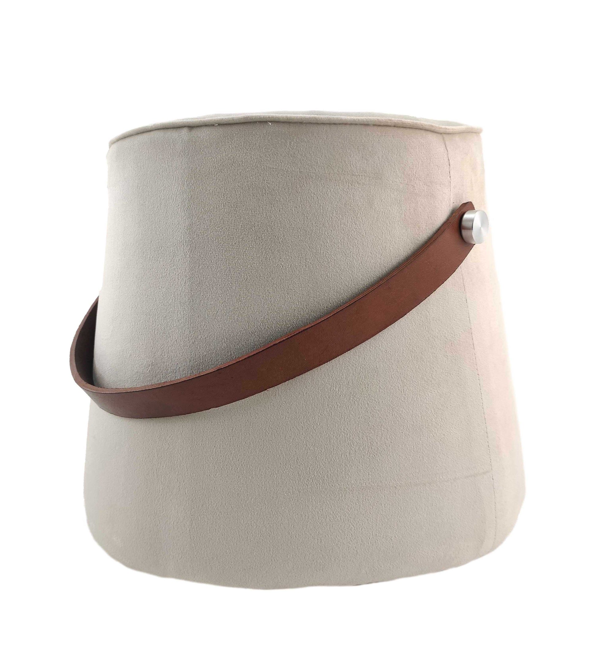 The RAMSHA HOME Leather Pedestal Pouf features a beige, cylindrical design with smooth leather and a brown strap handle secured by a silver button.