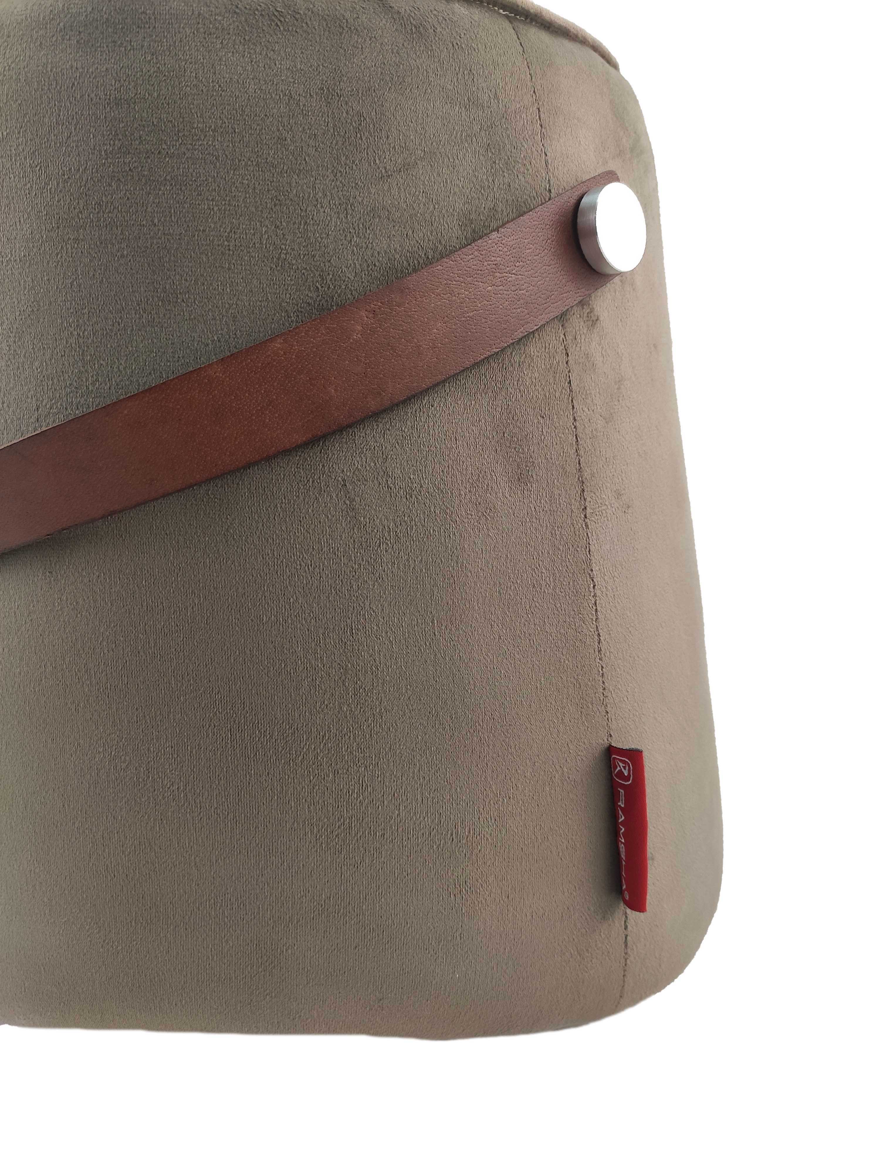 A close-up of the RAMSHA HOME Leather Pedestal Pouf with a brown leather handle and small red logo label, shown on a white background.