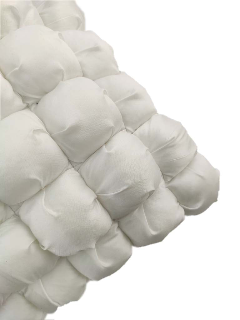 Close-up of RAMSHA HOME 100% Polyester Cushion Cover CS-111 featuring soft, white, fabric-filled pouches sewn in a grid pattern—an ideal modern accent for chic home decor.