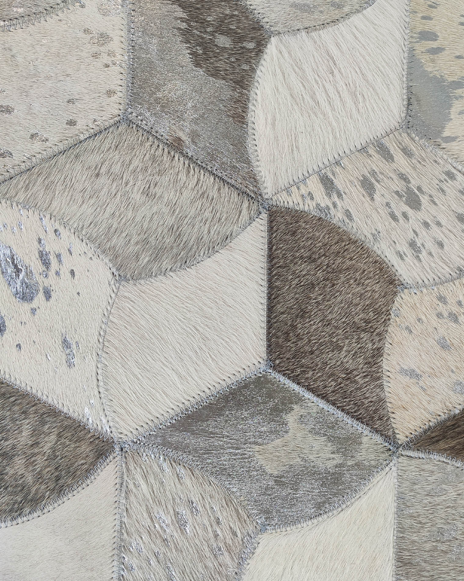 Close-up of the RAMSHA HOME Amazing Bedroom & Hallway Grey Color Leather Rug - LR 007, featuring hexagonal animal hide pieces in neutral tones with visible hair textures and stitched seams for a striking geometric look.