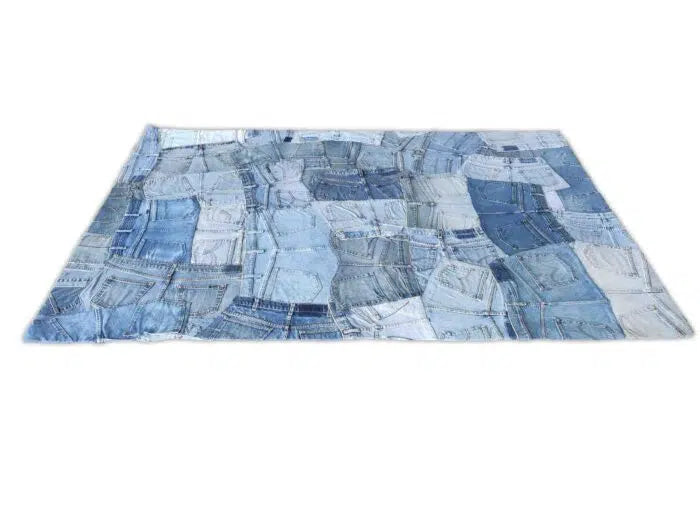 The Ramsha Home Multi Color Cotton Denim Rug – DN 001 features recycled jeans in blue hues with visible pockets and seams, arranged in a modern grid pattern that refreshes the classic dhurrie rug style.