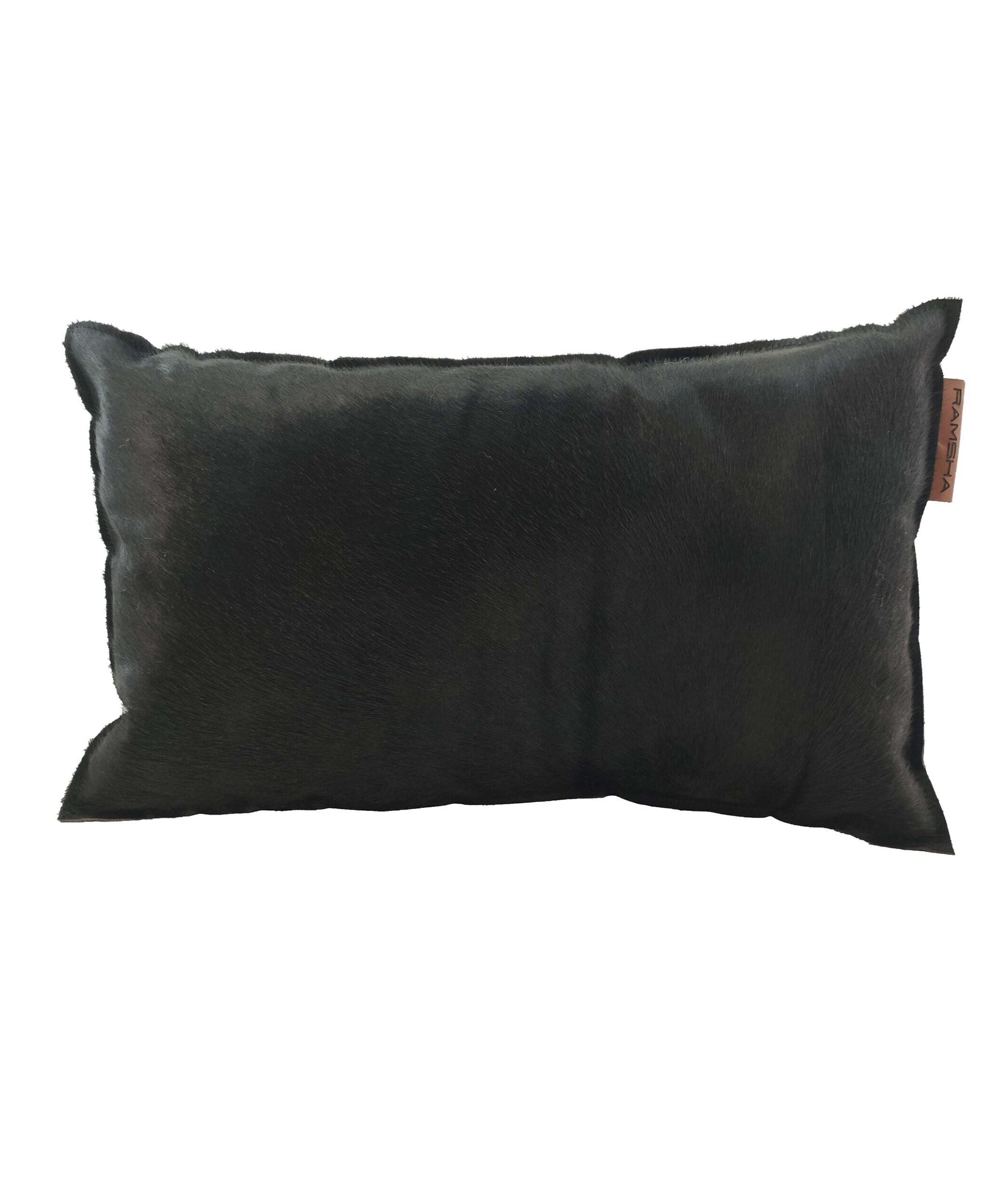The RAMSHA HOME Leather Cushion With Filler CS-091 is a rectangular, dark-toned luxurious cushion with a soft, furry texture and a small fabric tag on the side.