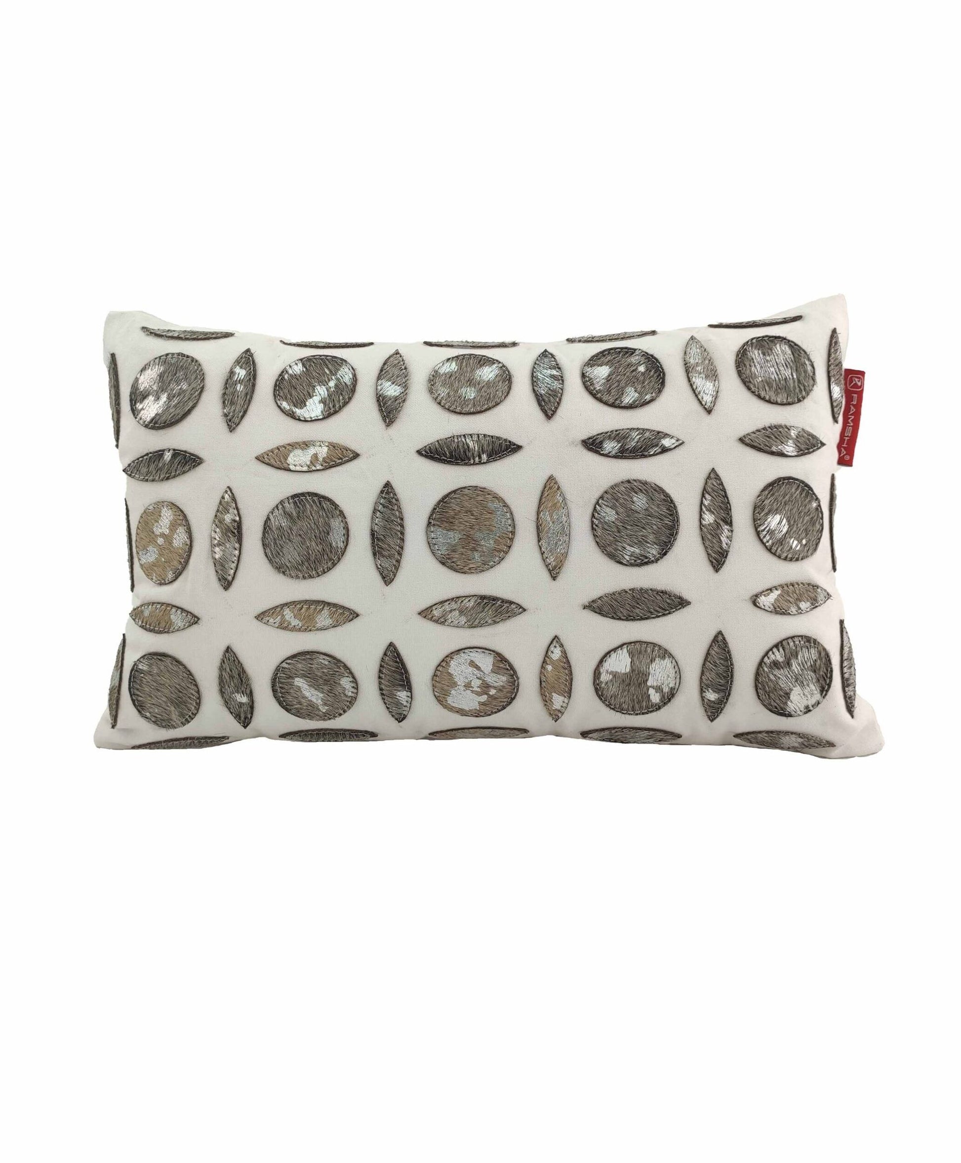 The RAMSHA HOME Polyester & Leather Cushion CS-101 is a rectangular white throw pillow featuring metallic silver and brown ovals and circles, plus a small red fabric tag on the right side—perfect as a stylish accent for your living space.