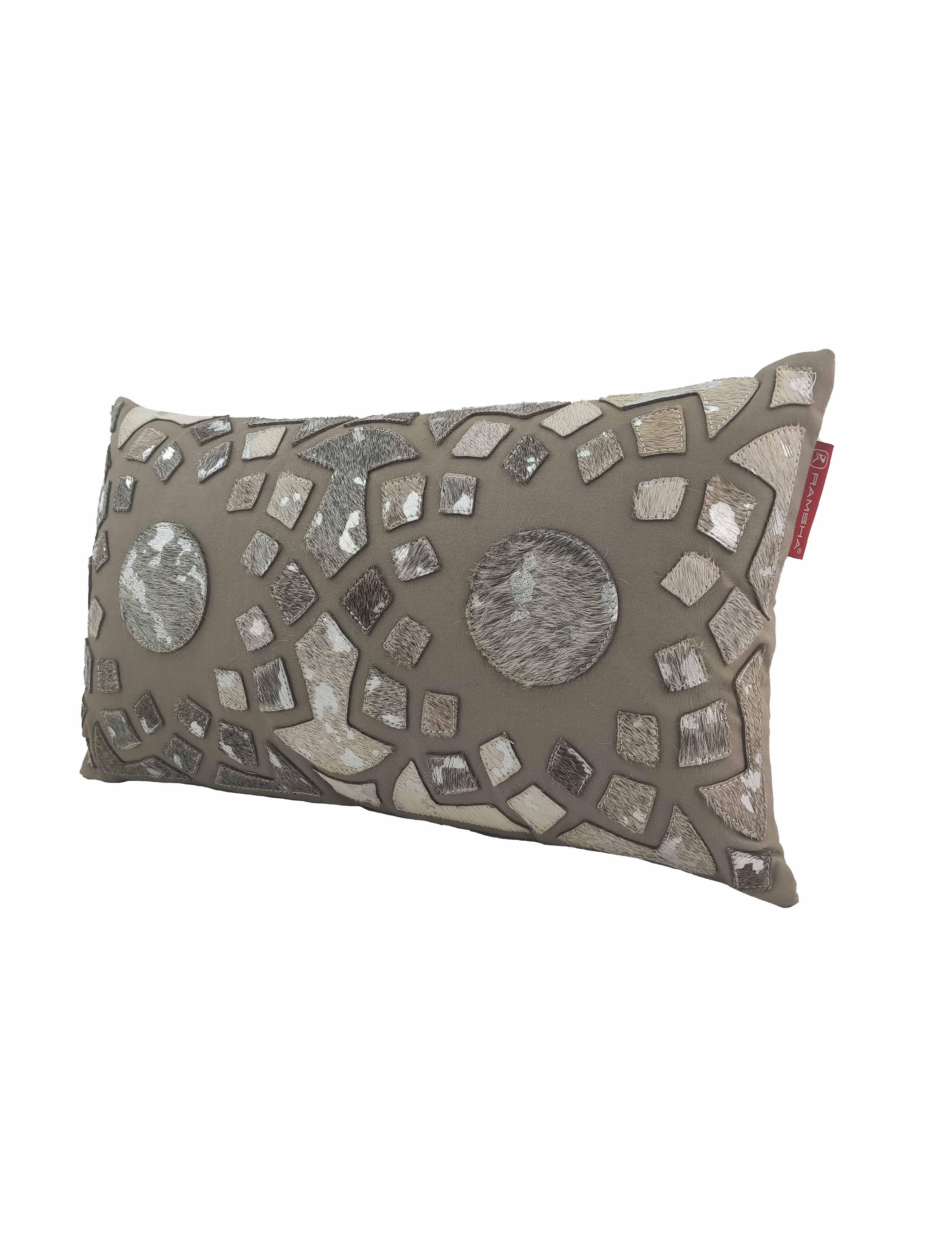 The RAMSHA HOME Decorative Cushion CS-105 features a taupe background with silver and grey geometric patches, two circular patterns, and a mosaic-like textured design in polyester and leather, finished with a red fabric tag.