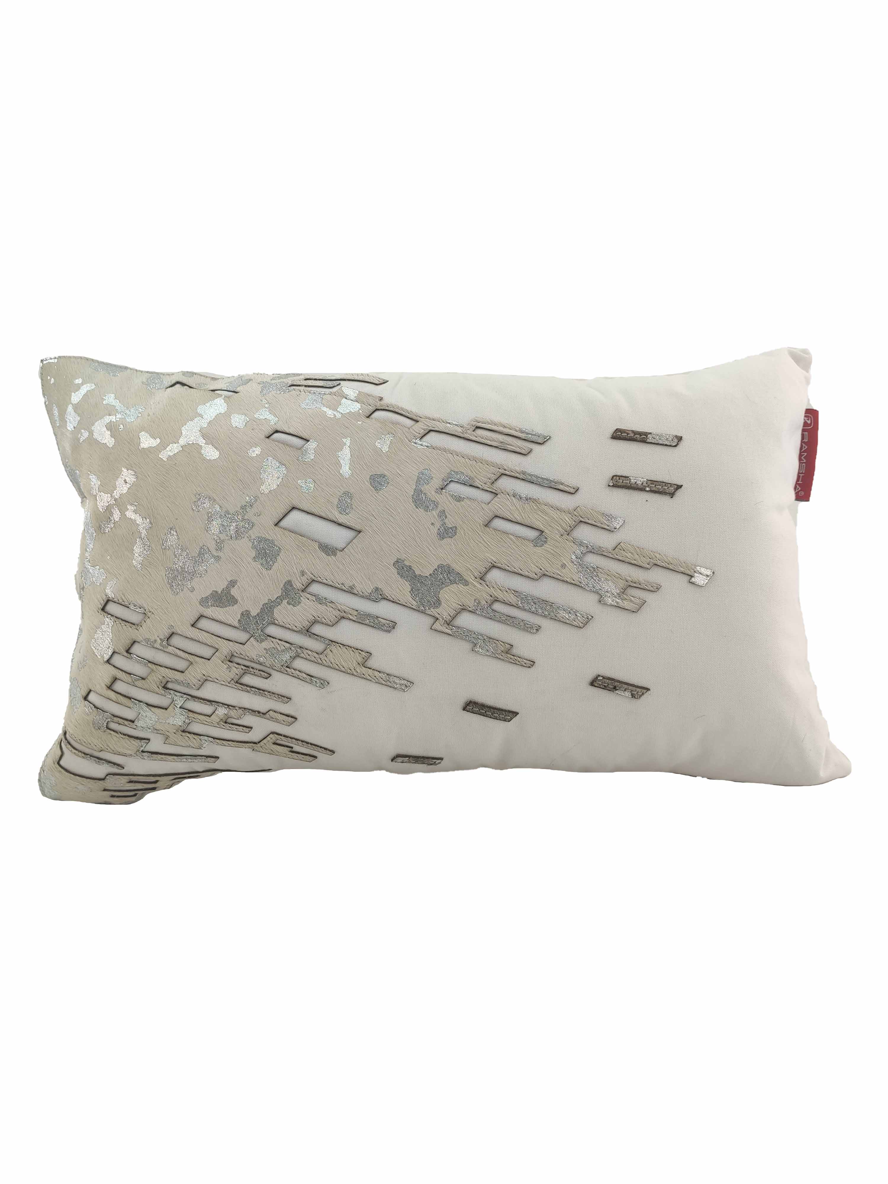 The RAMSHA HOME CS-108 Leather Decor Cushion is a rectangular white cushion with a geometric silver and beige embroidered pattern on one side and a small red fabric tag on the edge.