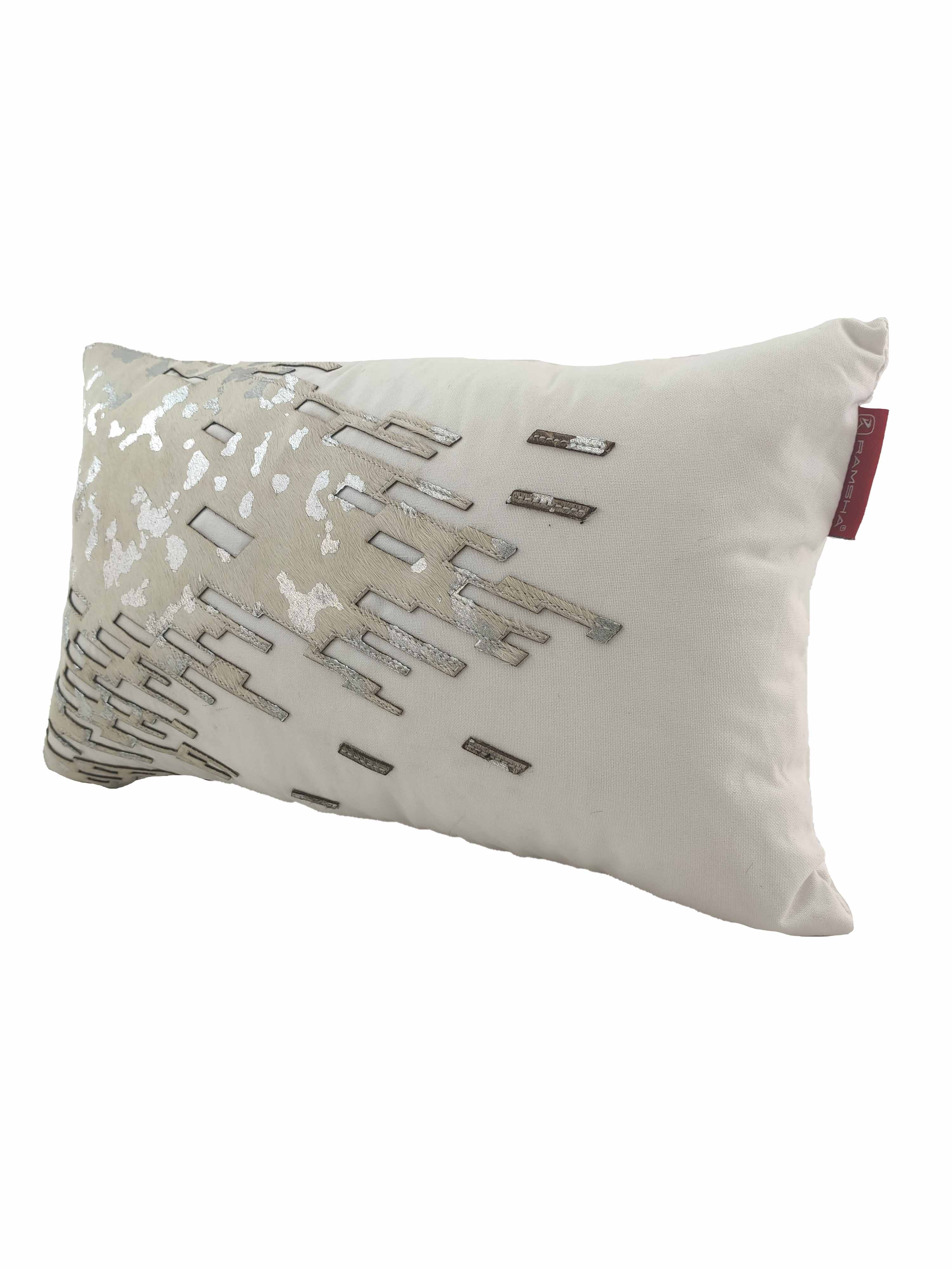 The RAMSHA HOME CS-108 Leather Decor Cushion is a rectangular white pillow featuring metallic silver and beige embroidered geometric patterns on one side and a red fabric tag on the right edge, displayed against a plain white background.