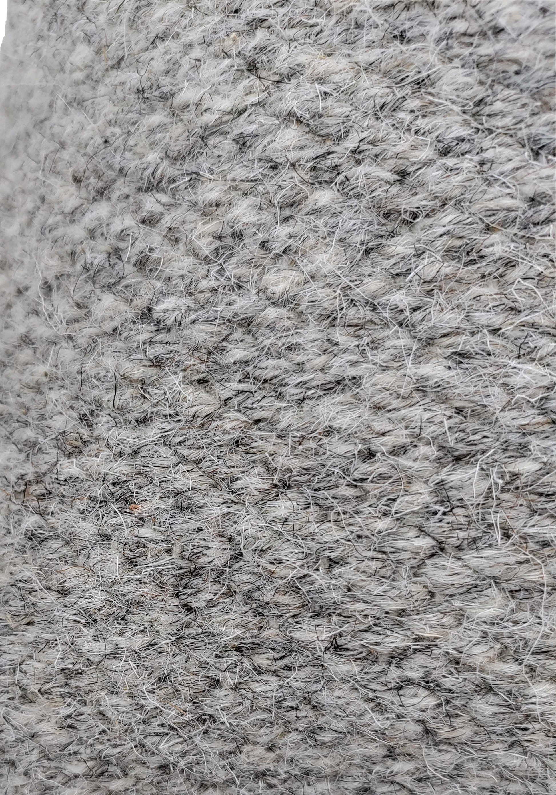Close-up of the textured gray Wool Cushion With Insert cs-142 by RAMSHA HOME, featuring visible fibers and a slightly rough surface. The detailed weave and yarn strands add style to any home decor.