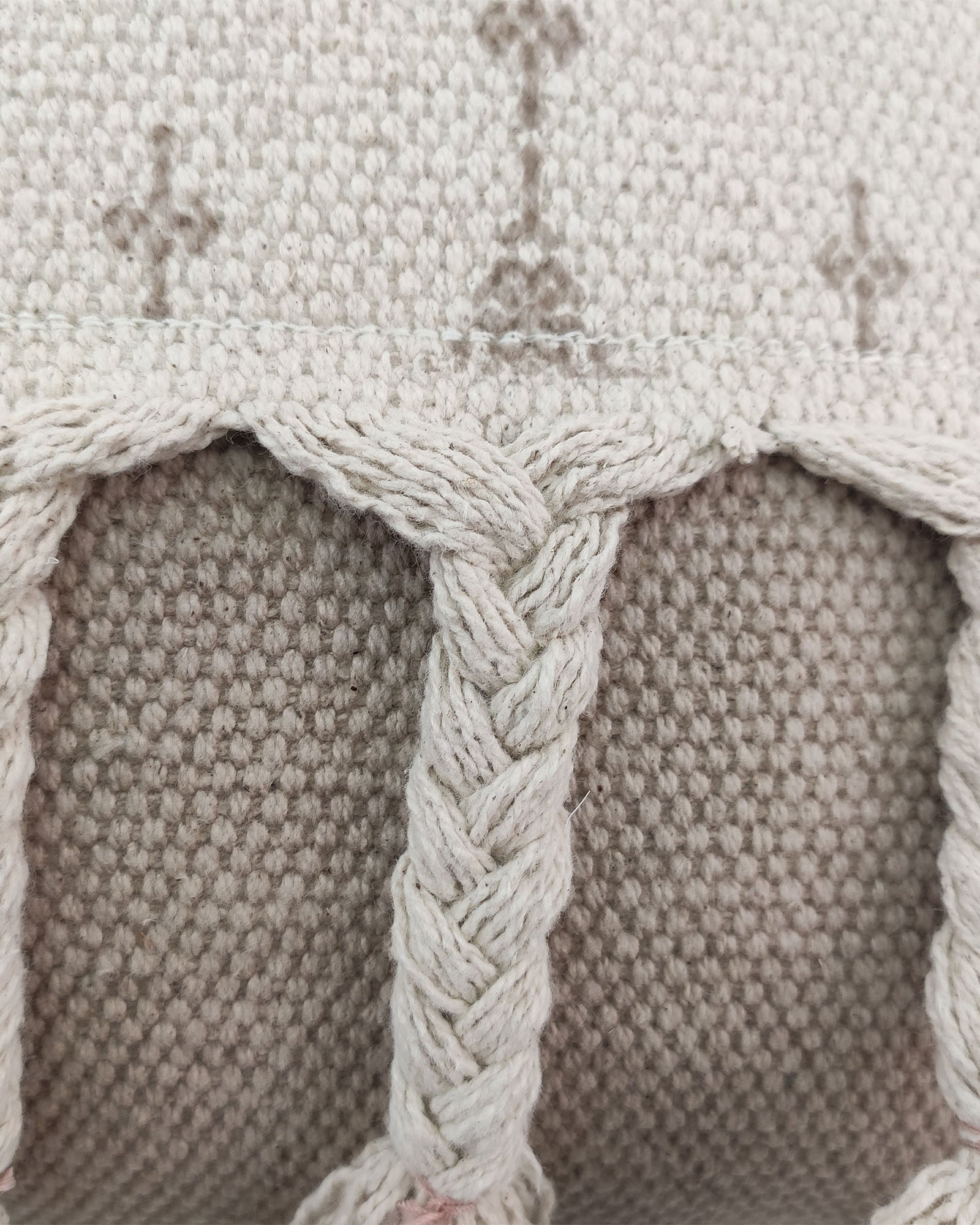 Close-up of the RAMSHA HOME Printed Cotton Cushion With Fringes cs-172, showing its textured cream and beige braided pattern, decorative stitching, and soft feel with a plush insert.