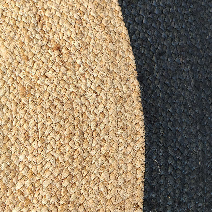 Close-up of RAMSHA HOME’s Beautiful Handmade Braided Jute Floor Round Rug - BR 057 (200cm), featuring natural beige and black sections that highlight its textured, detailed braiding and add style to any room.