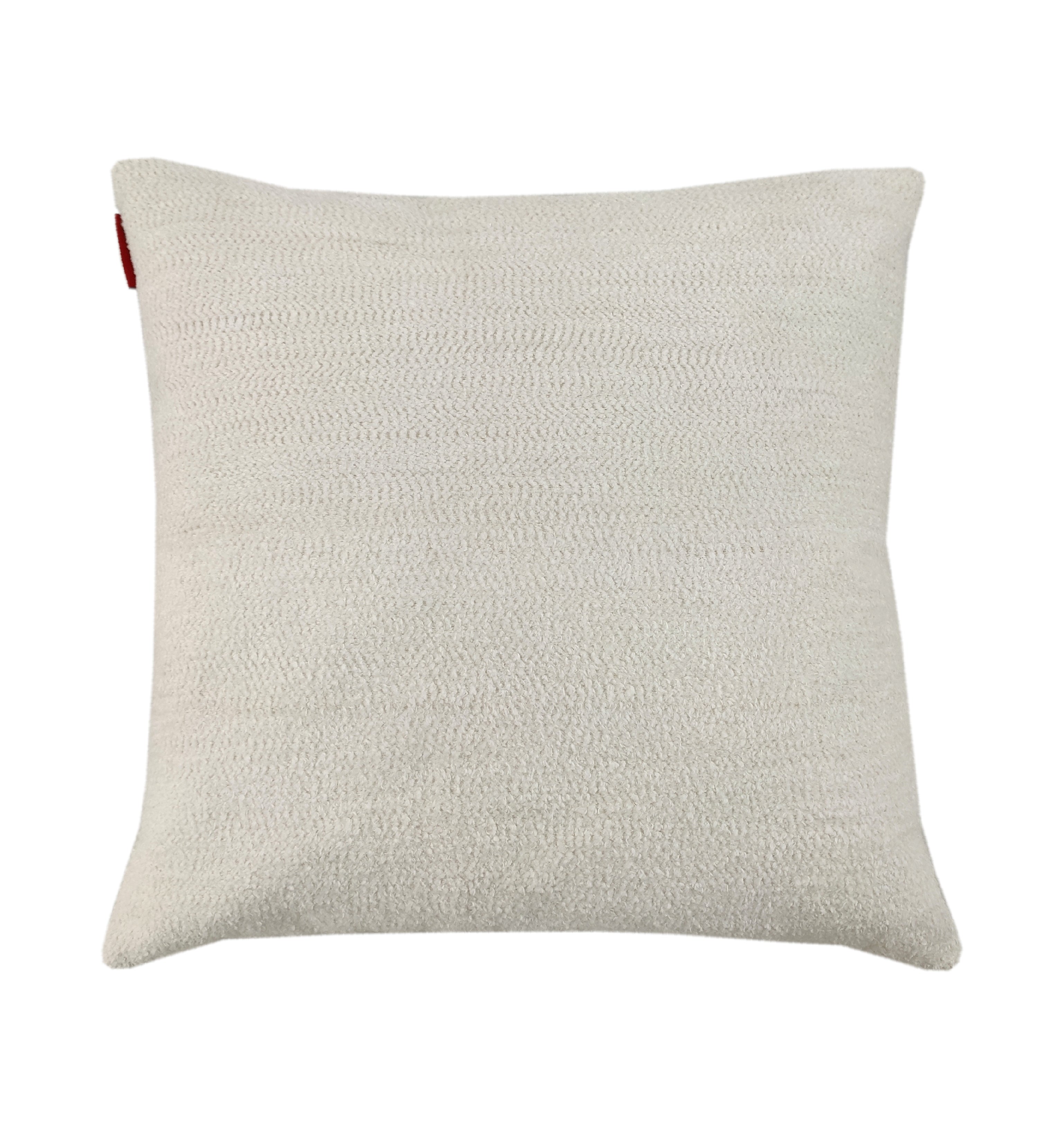 The RAMSHA HOME Boho Cushion With Small Furr is a square, off-white textured cushion with a subtle woven pattern, soft Poly Fill Cotton, and a small red tag in one corner, shown on a plain white background.