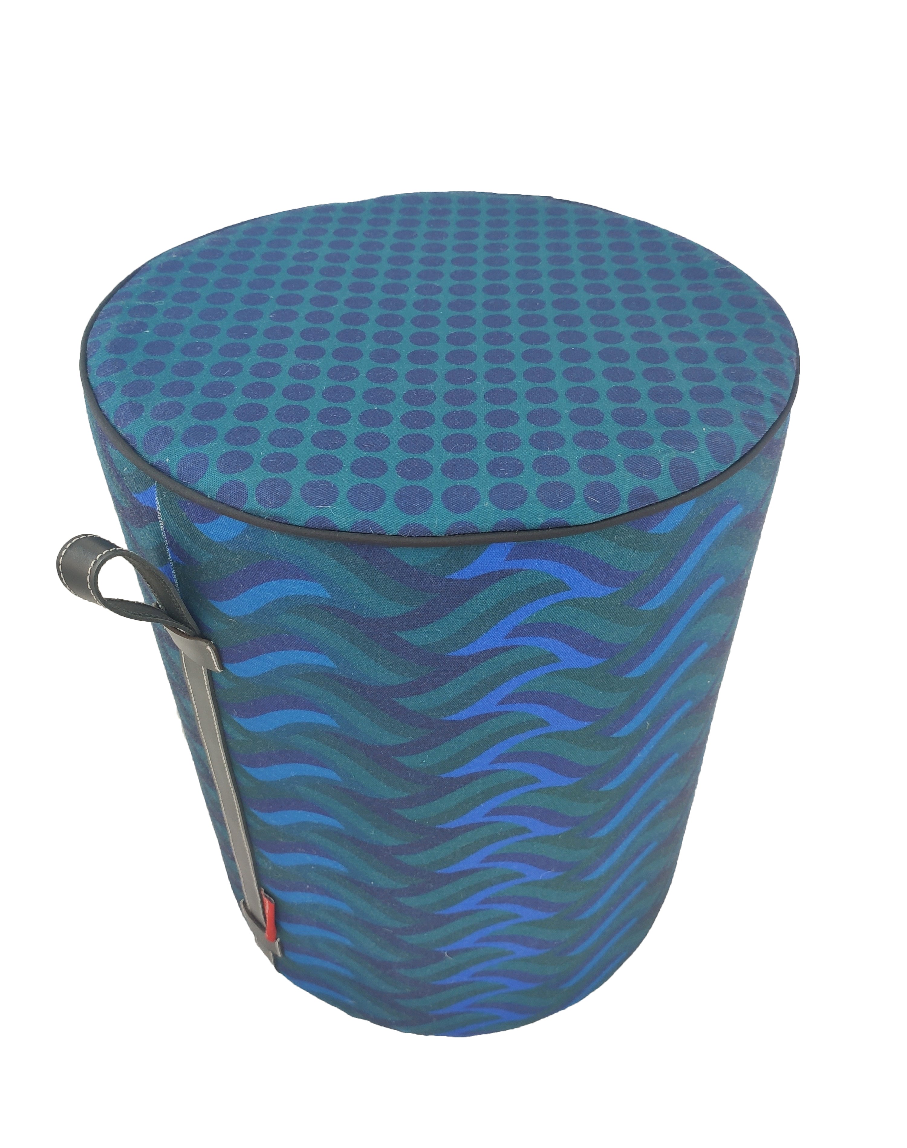 Add style to your home with the RAMSHA HOME Blue Printed Pedestal Pouf With Leather Handle PF-037, featuring a cylindrical shape, dark blue dot and wavy stripe patterns, leather handle, and small red tag.