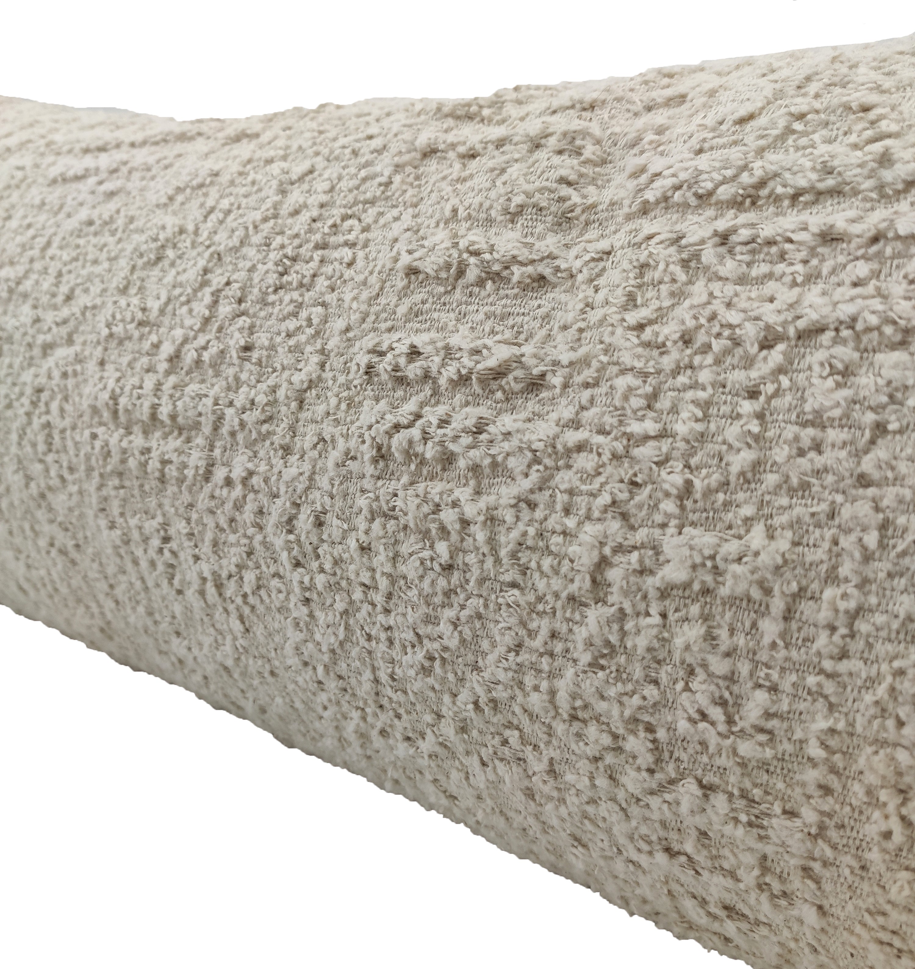 Close-up of the RAMSHA HOME Boho Cushion With Small Furr, wrapped in beige textured fabric with a subtle geometric pattern. The soft, slightly raised surface suggests plush comfort, likely thanks to its Poly Fill Cotton filling for added support.