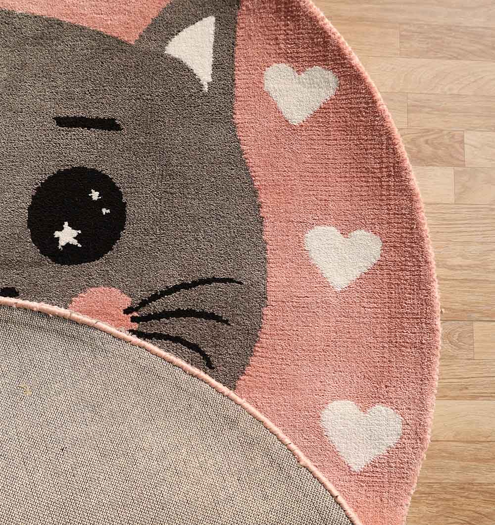 The RAMSHA HOME Kids Cat Rug - Pink & Grey Playroom Area Carpet (KD 009, 120 cm) showcases a cute cartoon cat face on a pink background with white hearts, with a flipped corner revealing the underside—perfect for wooden floors.