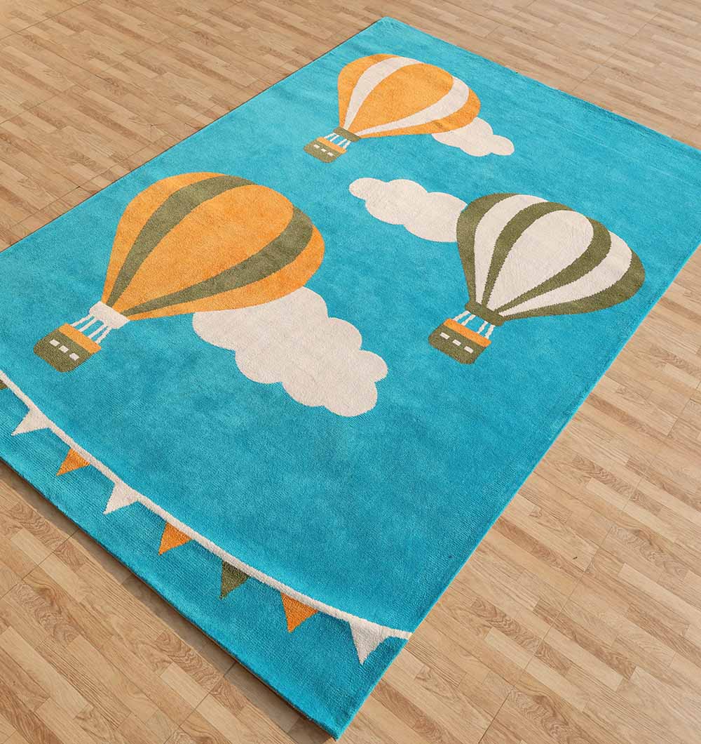 The RAMSHA HOME Modern Kids Area Rug - KD 012 (120x180 cm) features a rectangular blue design with three illustrated hot air balloons, two clouds, and colorful pennants—ideal for a kids playroom, especially on wooden floors.